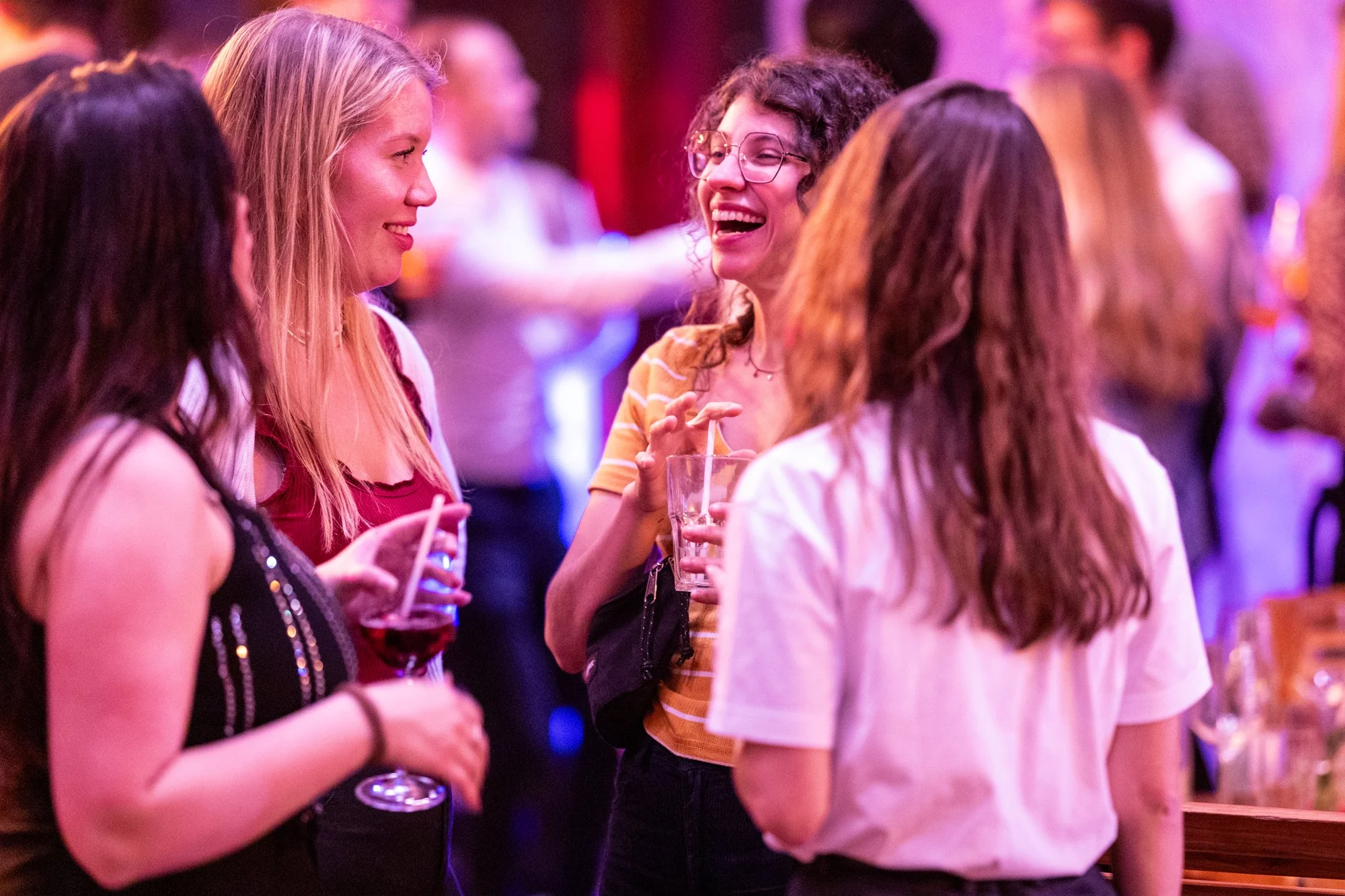 4 junge Damen stehen zusammen und Kreis und unterhalten sich lachend