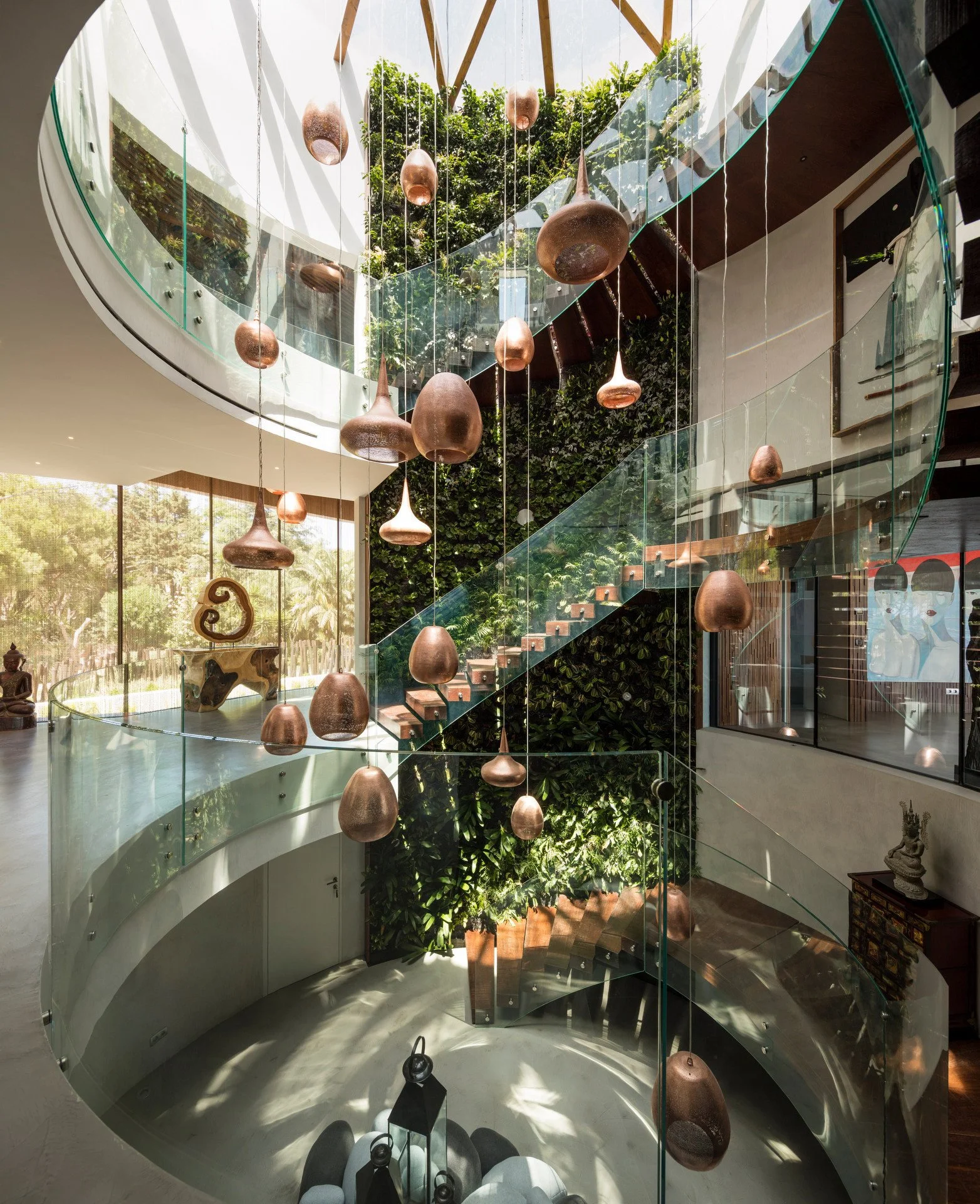 Stunning stairwell harmonizing natural and artificial light sources with a statement lighting piece in the middle and a ceiling with an intricate wood design