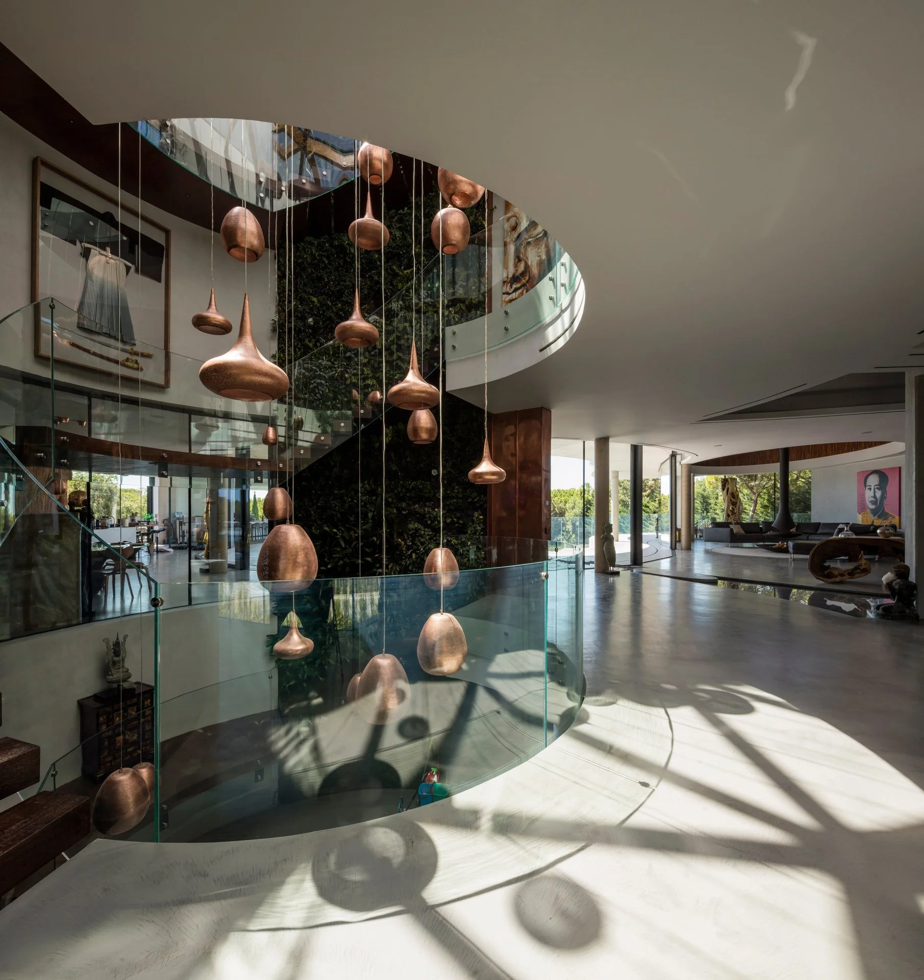 Stunning stairwell harmonizing natural and artificial light sources with a statement lighting piece in the middle and a ceiling with an intricate wood design