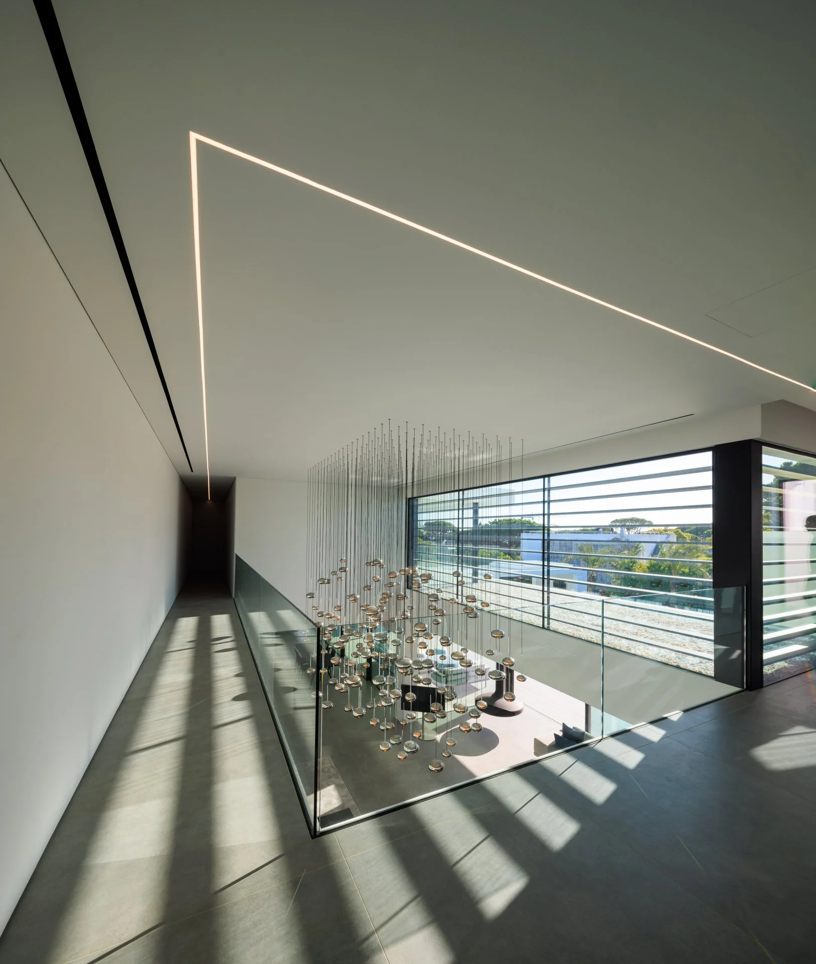 Living room project oozing luxury with double height ceiling and a lighting feature by Beau Design taking center stage