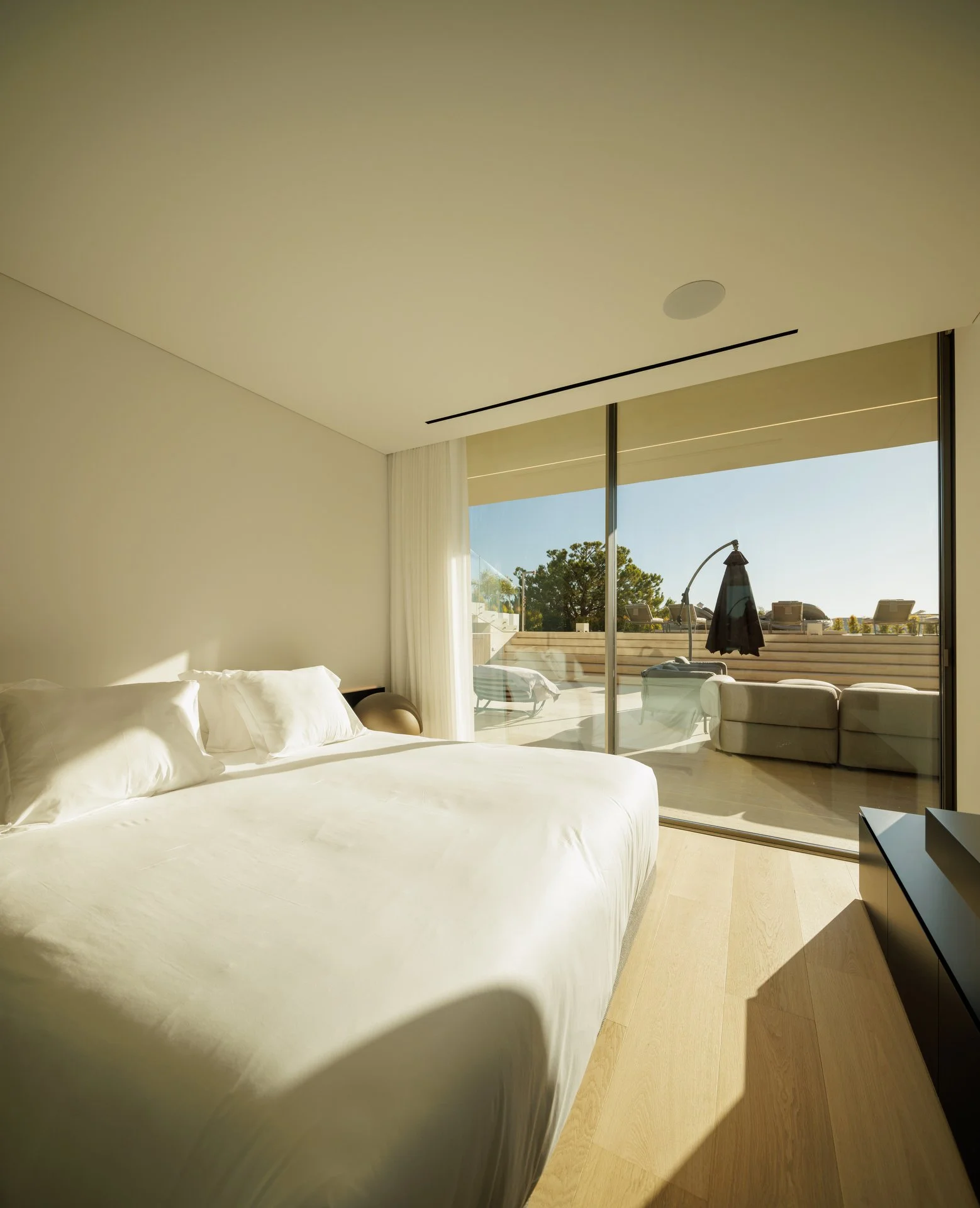 Sleek white bedroom by A+ Interiors 