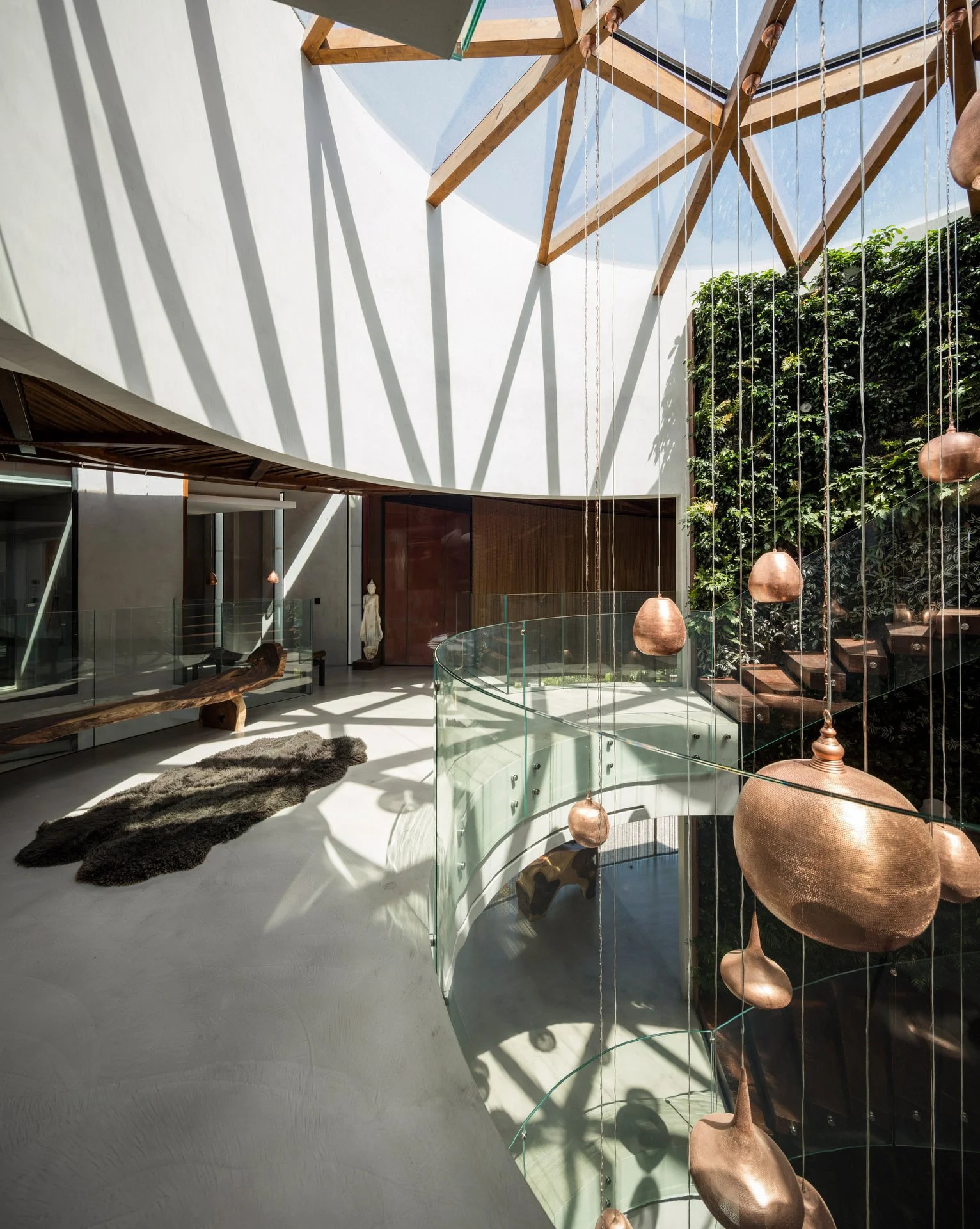 Stunning stairwell harmonizing natural and artificial light sources with a statement lighting piece in the middle and a ceiling with an intricate wood design
