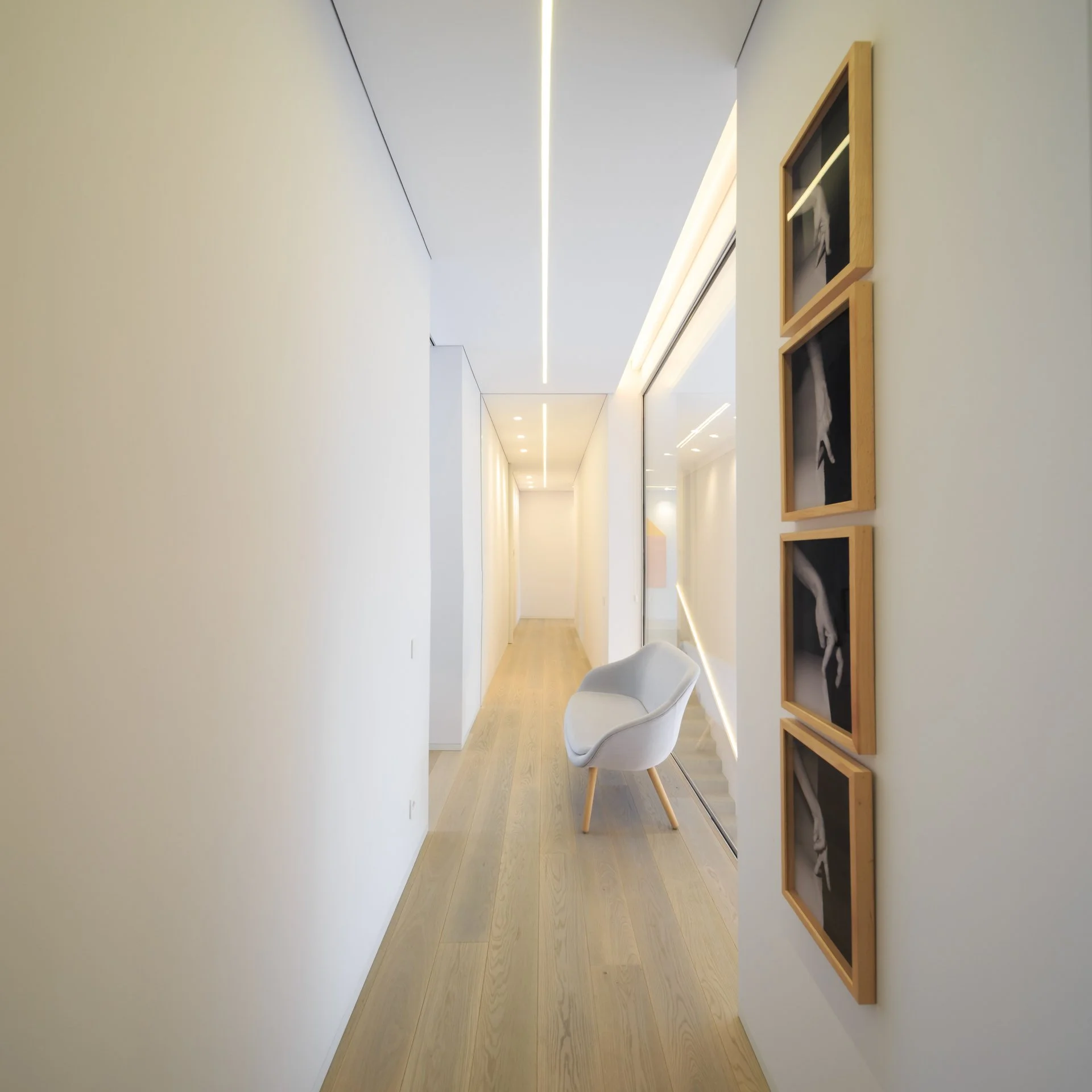 Bright corridor with light wooden floors showcasing artist Helena Almeida’s work
