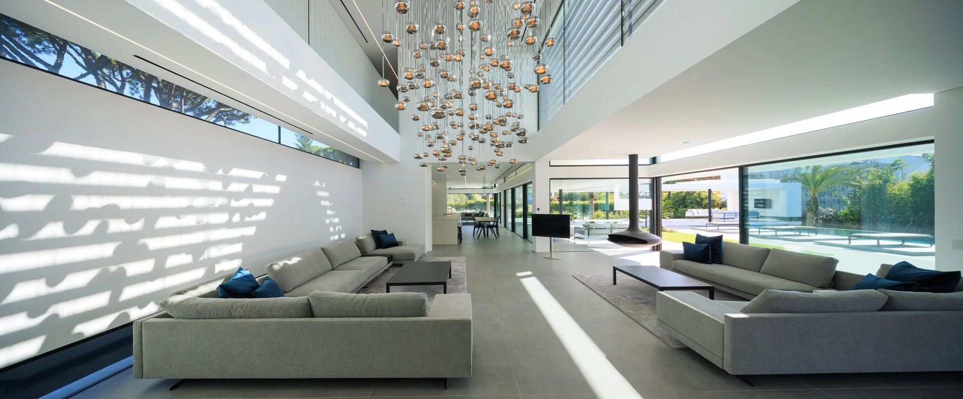 Living room project oozing luxury with double height ceiling and a lighting feature by Beau Design taking center stage