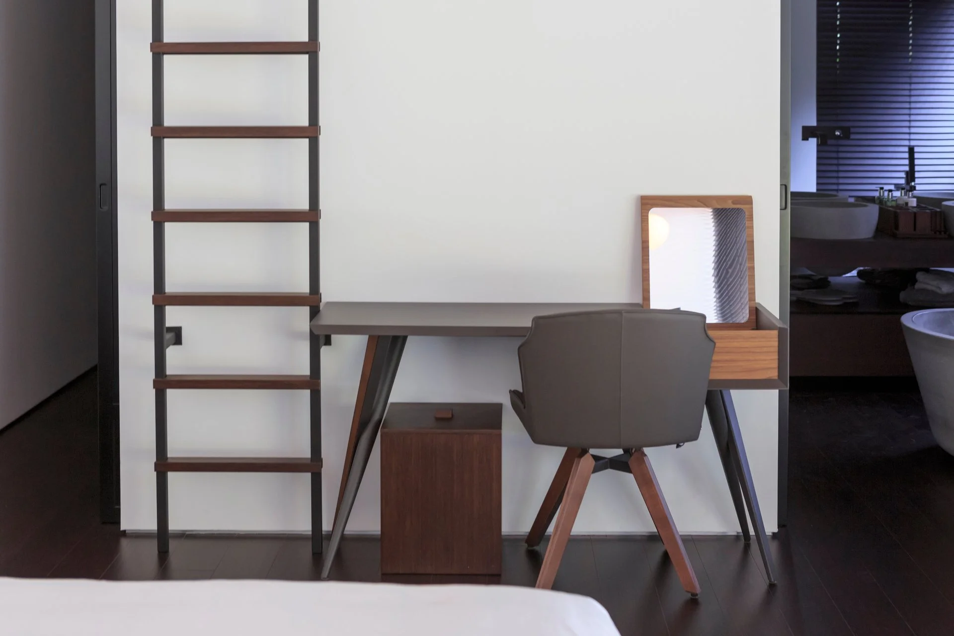 Modern wooden vanity with a grey chair 