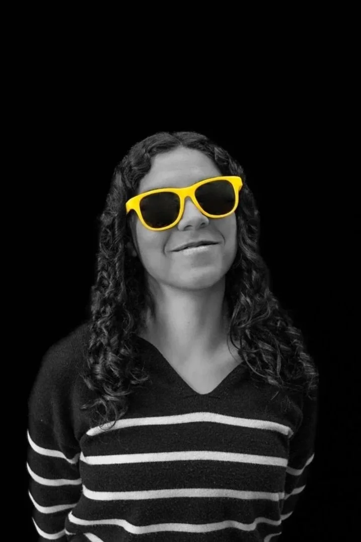 a woman in a black and white photo with yellow glasses