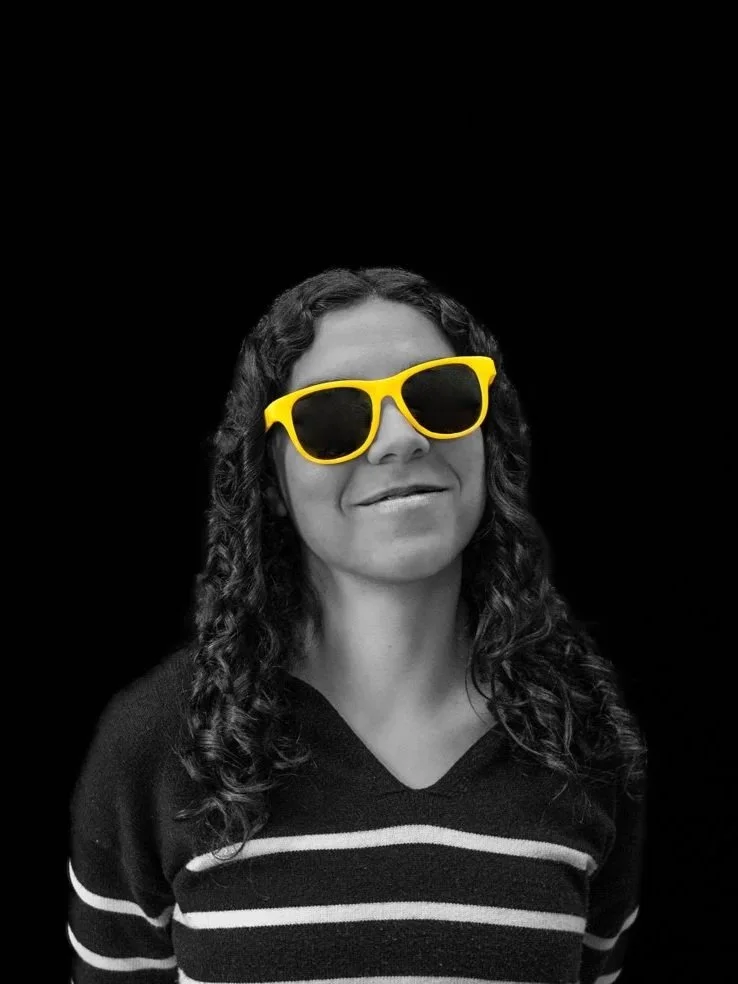 a woman in a black and white photo with yellow glasses