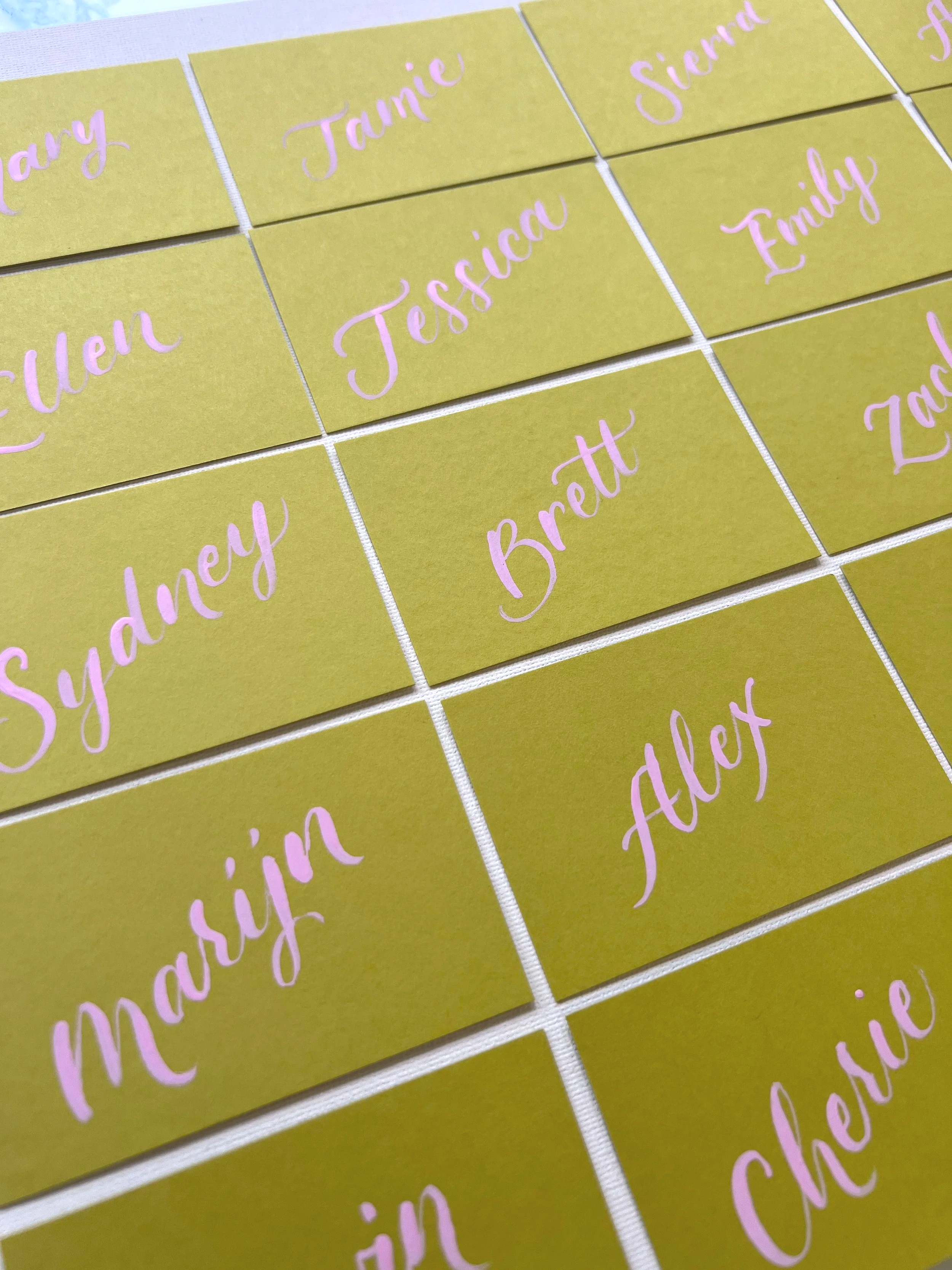 Brush calligraphy on chartreuse place cards for a wedding