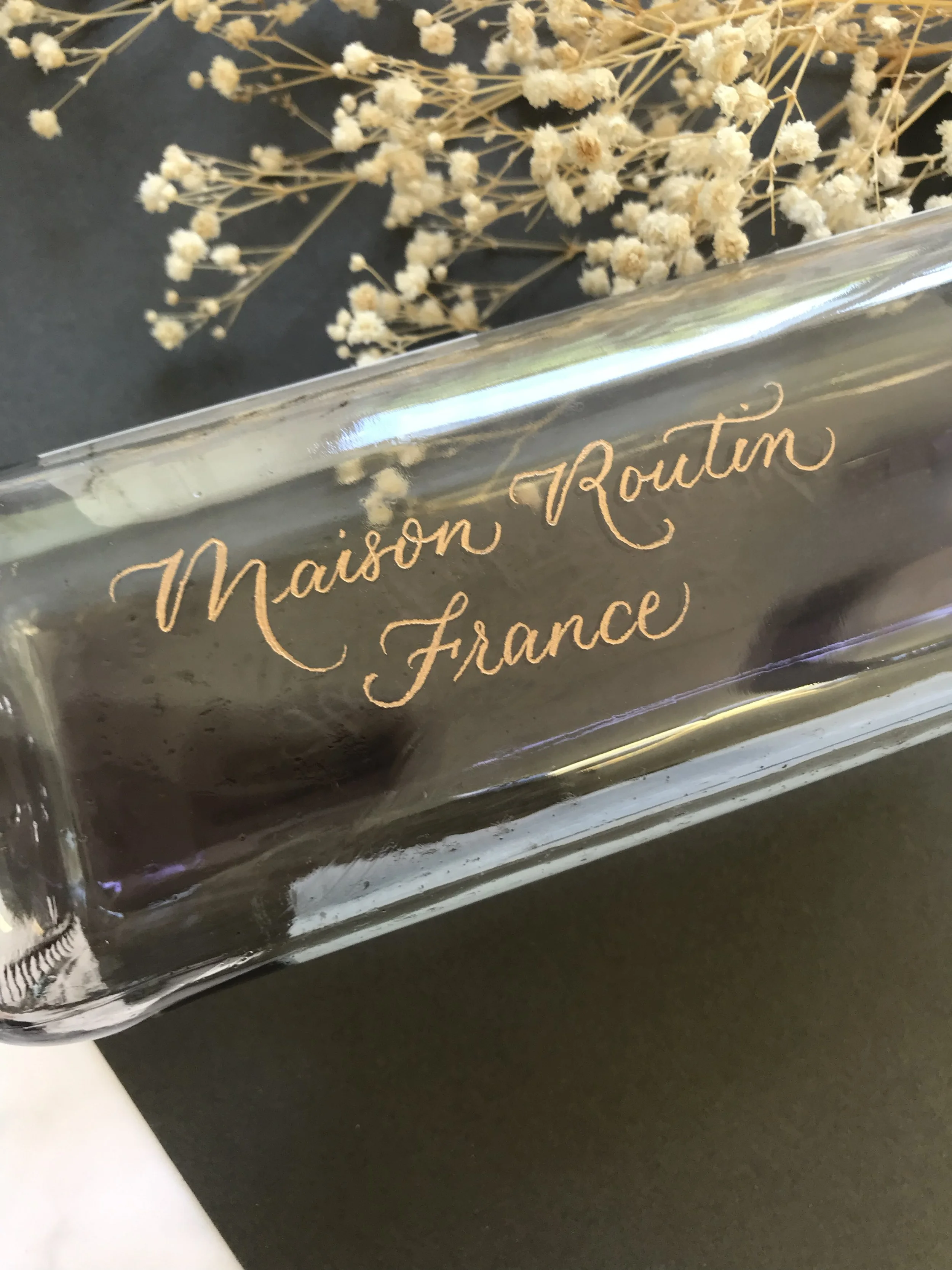 Engraving on a Maison Routin syrup bottle in studio
