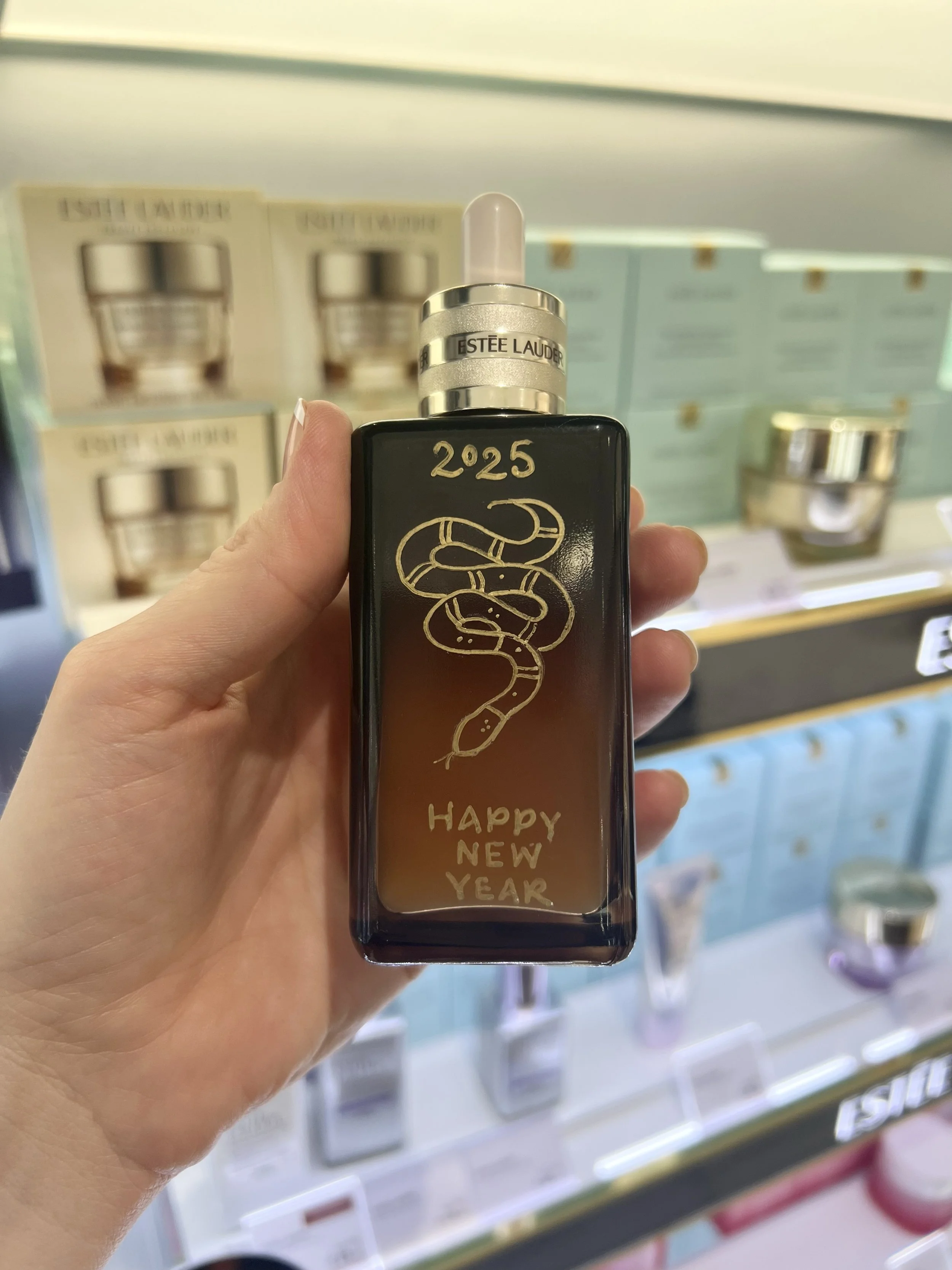 Live hand illustration of snake design on Estée Lauder bottle for Chinese New Year brand activation