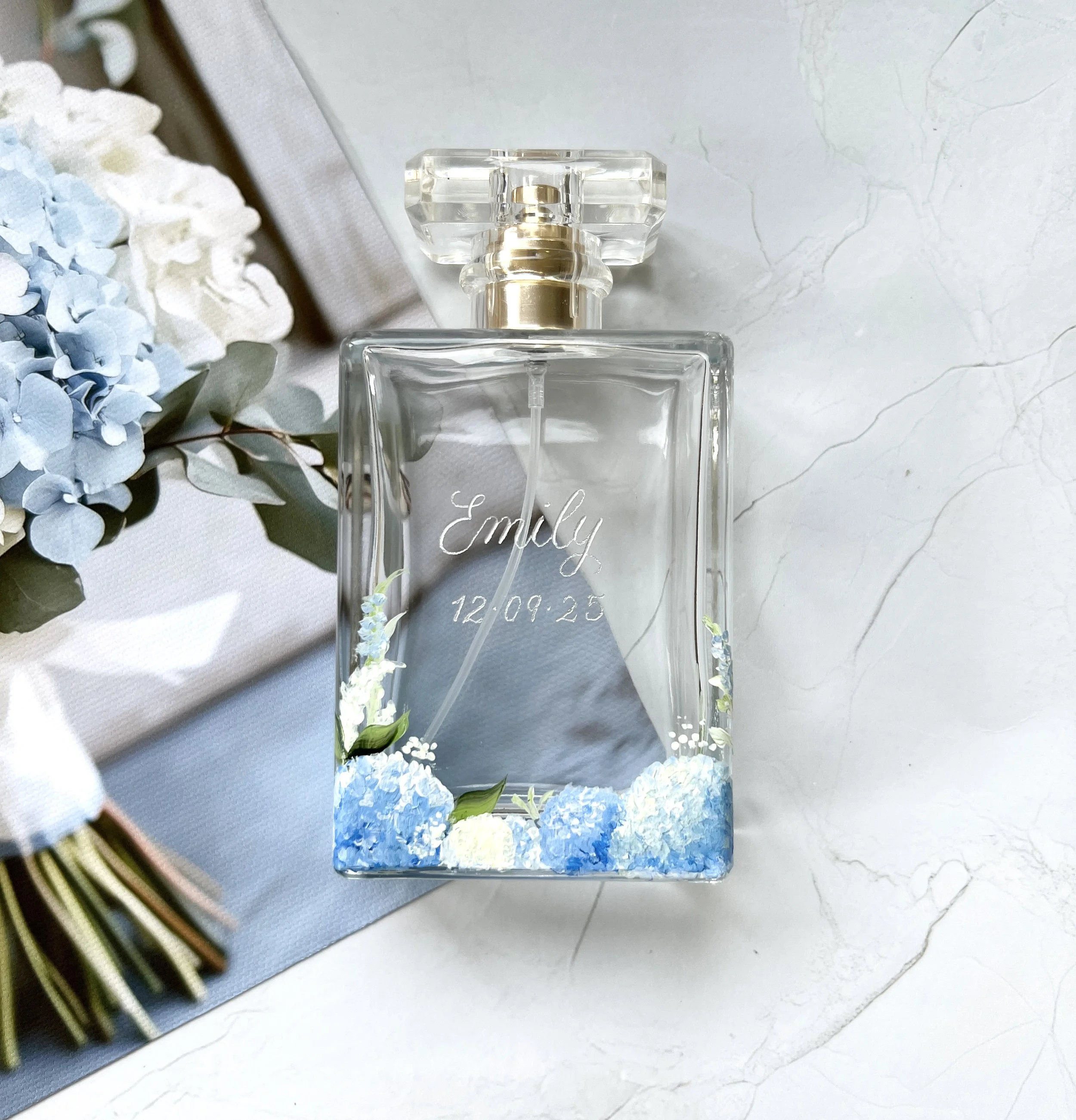 Hand-painted personalised perfume bottle with blue and white floral hydrangea design and silver calligraphy engraved name and date