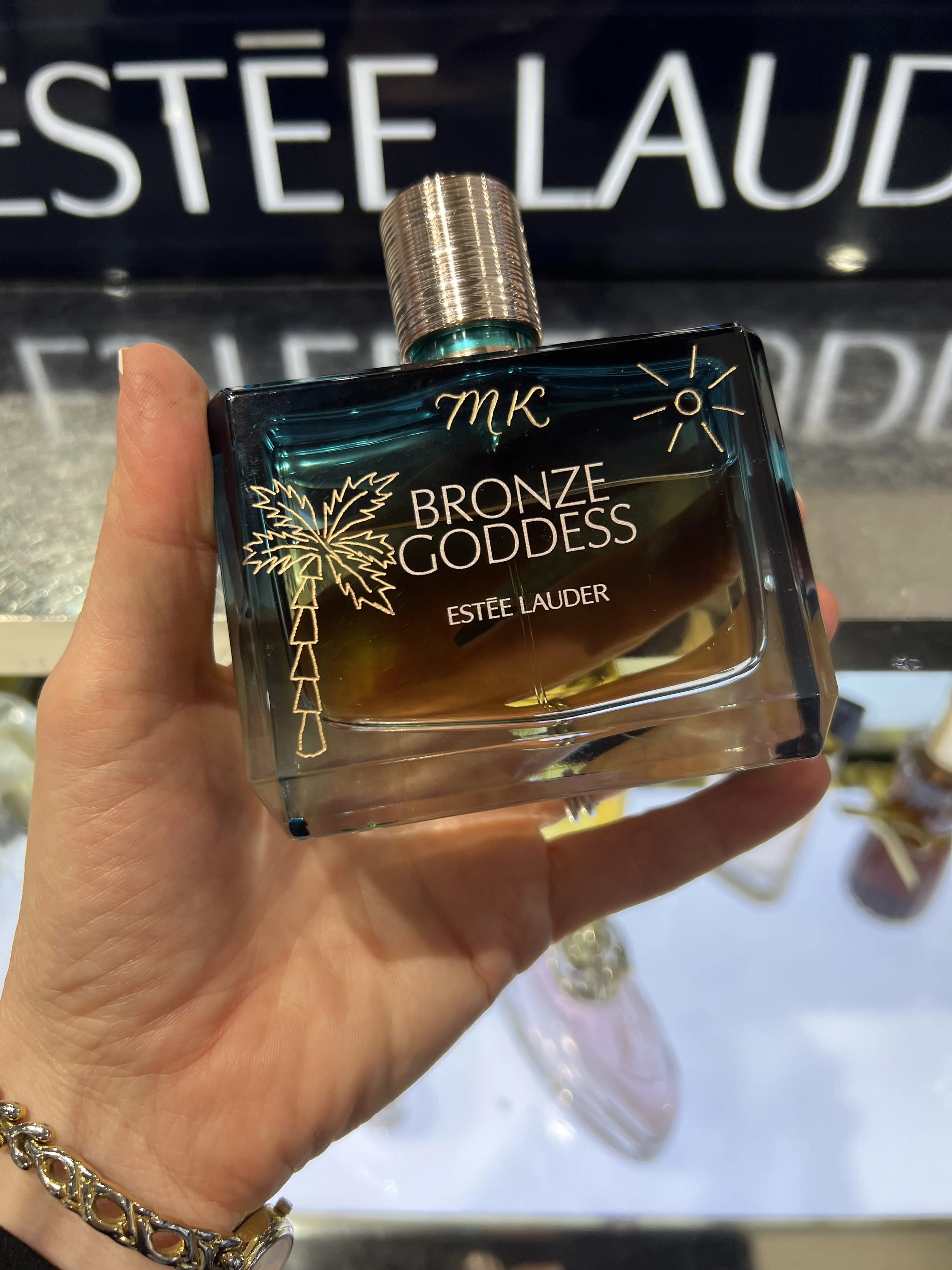 Hand engraved Estée Lauder Bronze Goddess perfume bottle at a live brand event