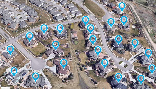 Aerial view of a suburban neighborhood with multiple houses, streets, and cul-de-sacs, each marked with a blue location pin.