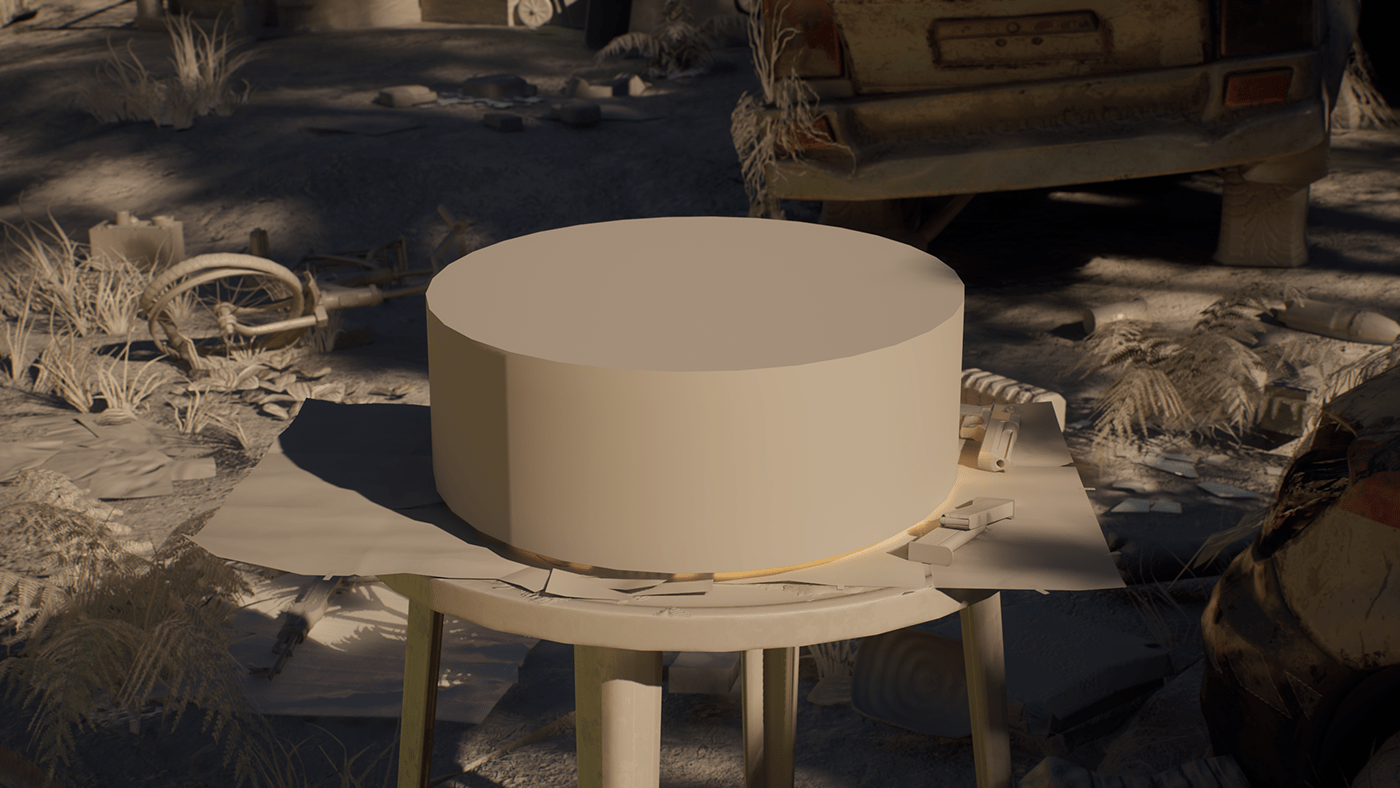 A round cake on a table outdoors amidst desert debris and abandoned cars.