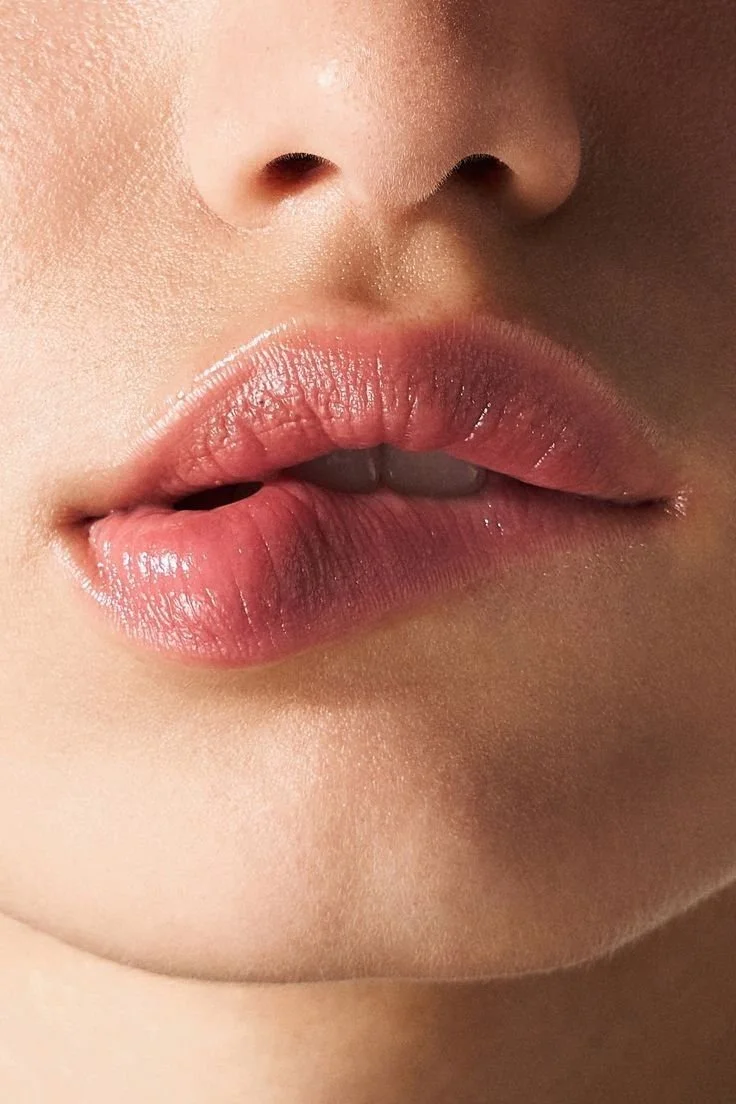 Close-up of a person's lips, slightly parted, showing a tongue between the lips.