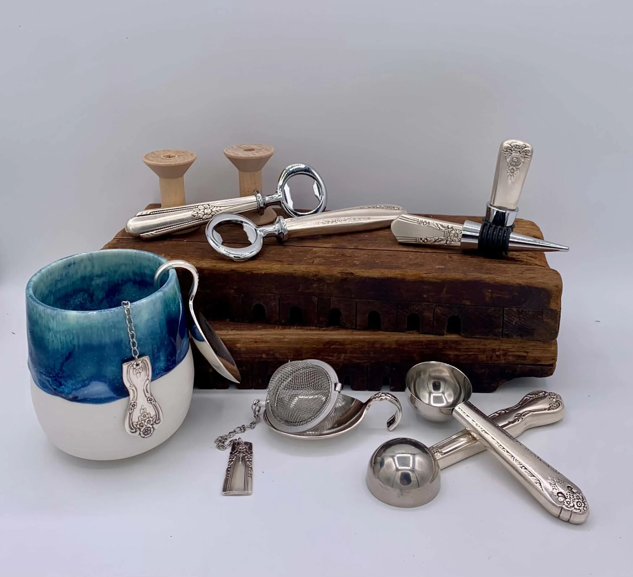 Serving Silver:
Functional kitchen and bar accessories including bottle openers, wine stoppers, coffee scoops, and handcrafted tea infusers, all created from repurposed vintage flatware.