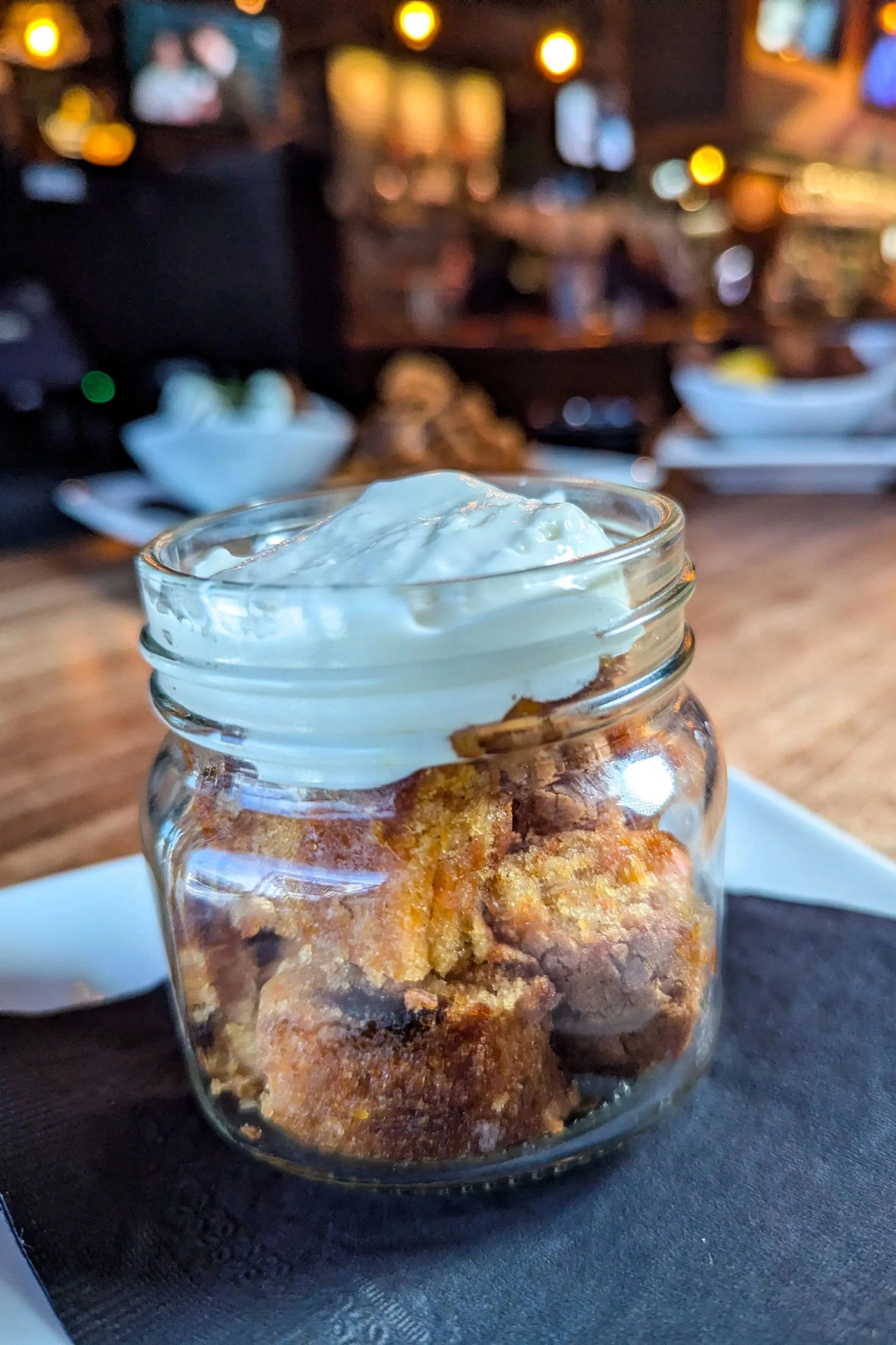 Carrot Cake with Cinnamon Whisky icing.  in a glass jar on a white plate at a pub.
