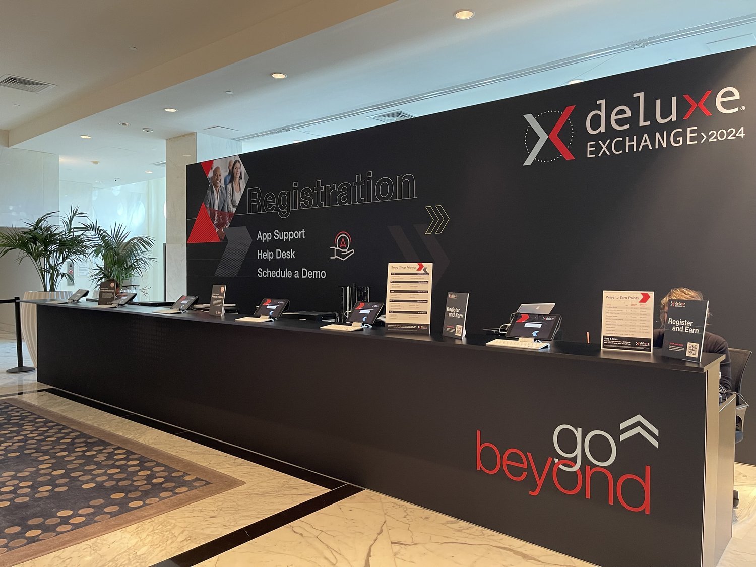 Event registration desk with branded wall and counter.