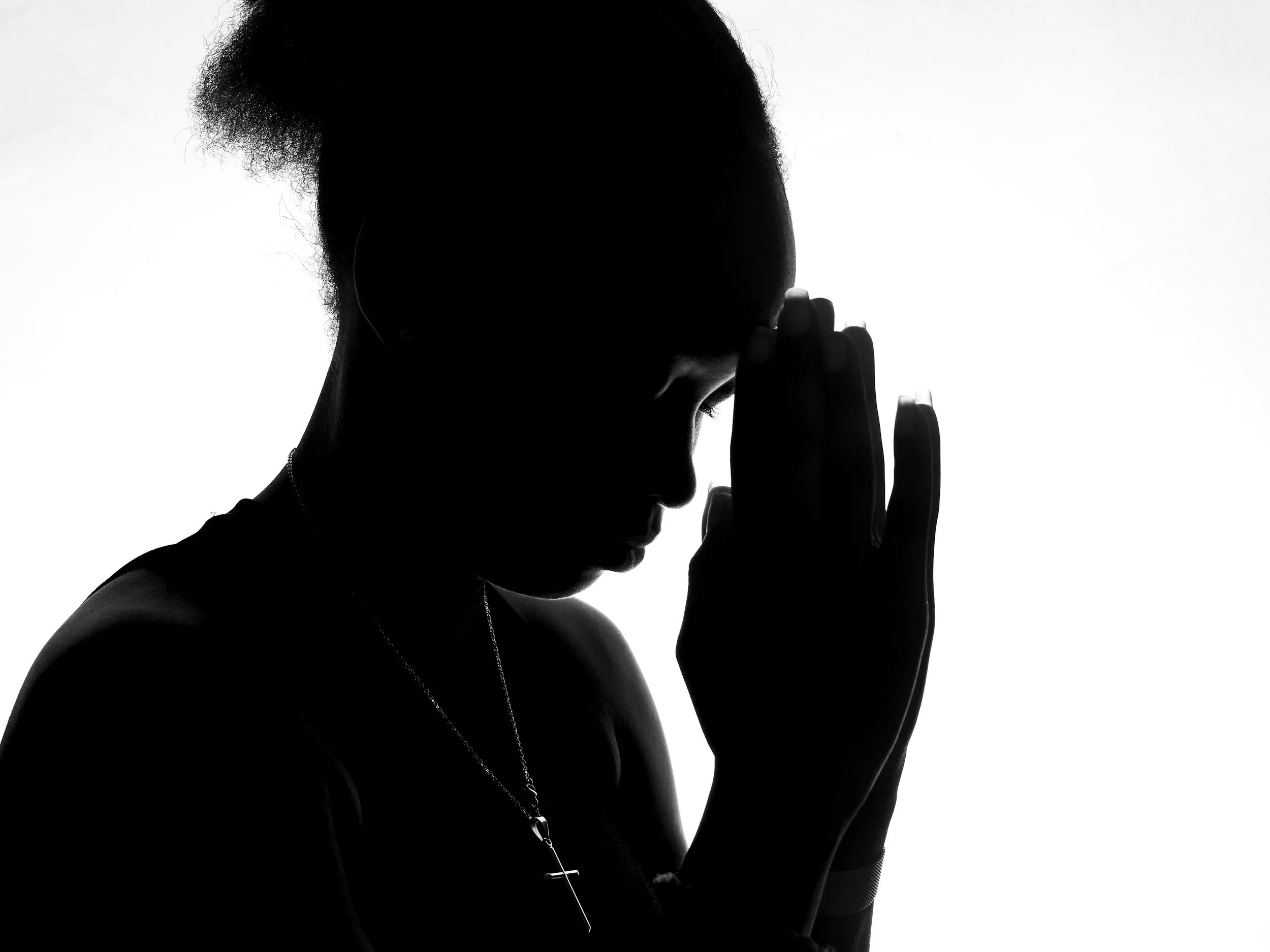 Silhouette of a mom praying.