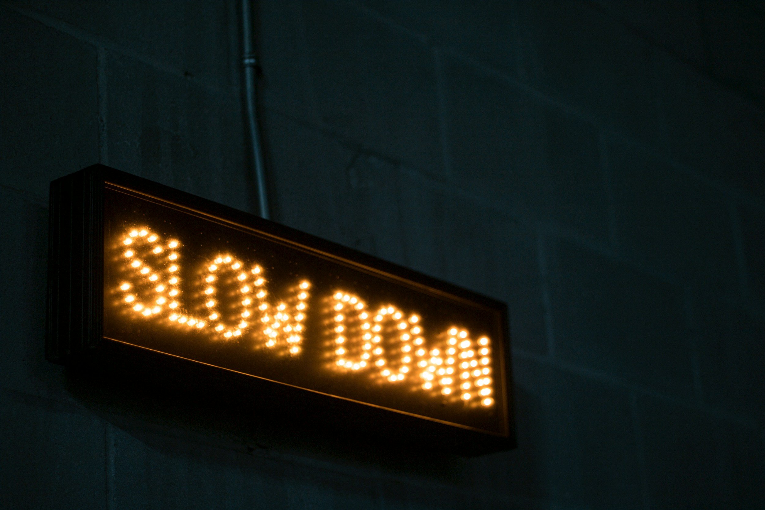 A lit sign that says slow down