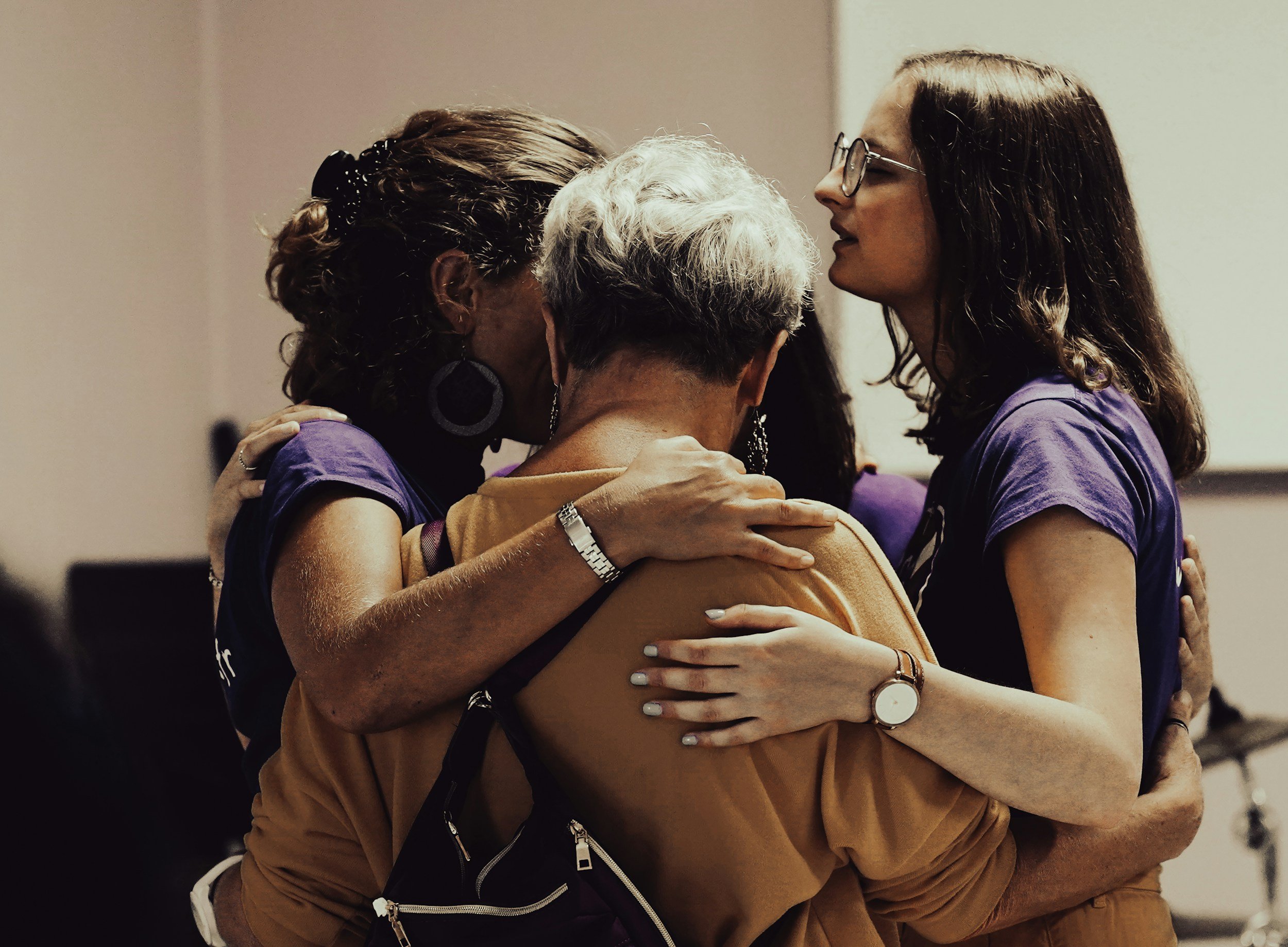 Group of women embraced in a circle praying