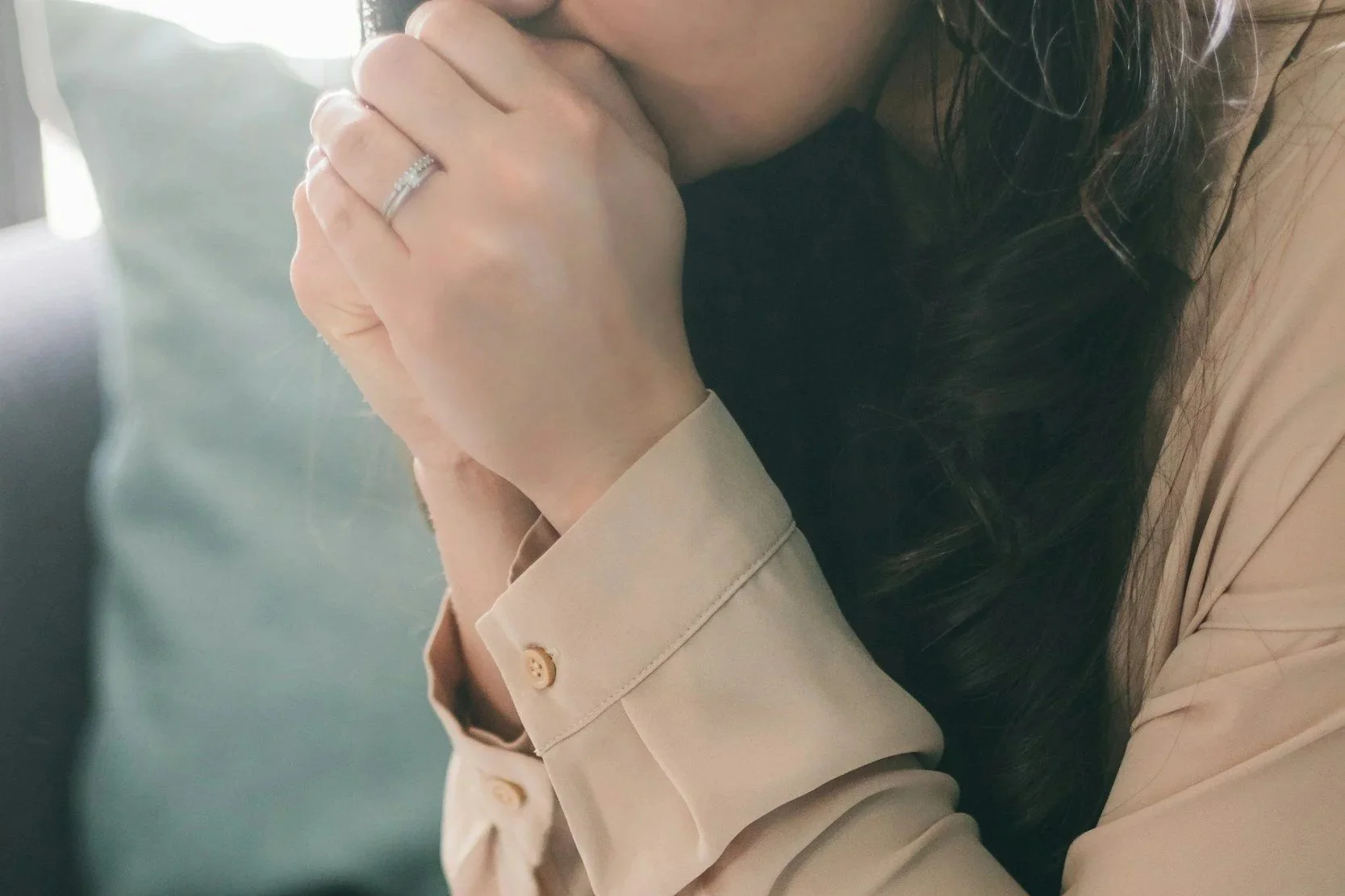 Caucasian mom with prayer hands to her chin.