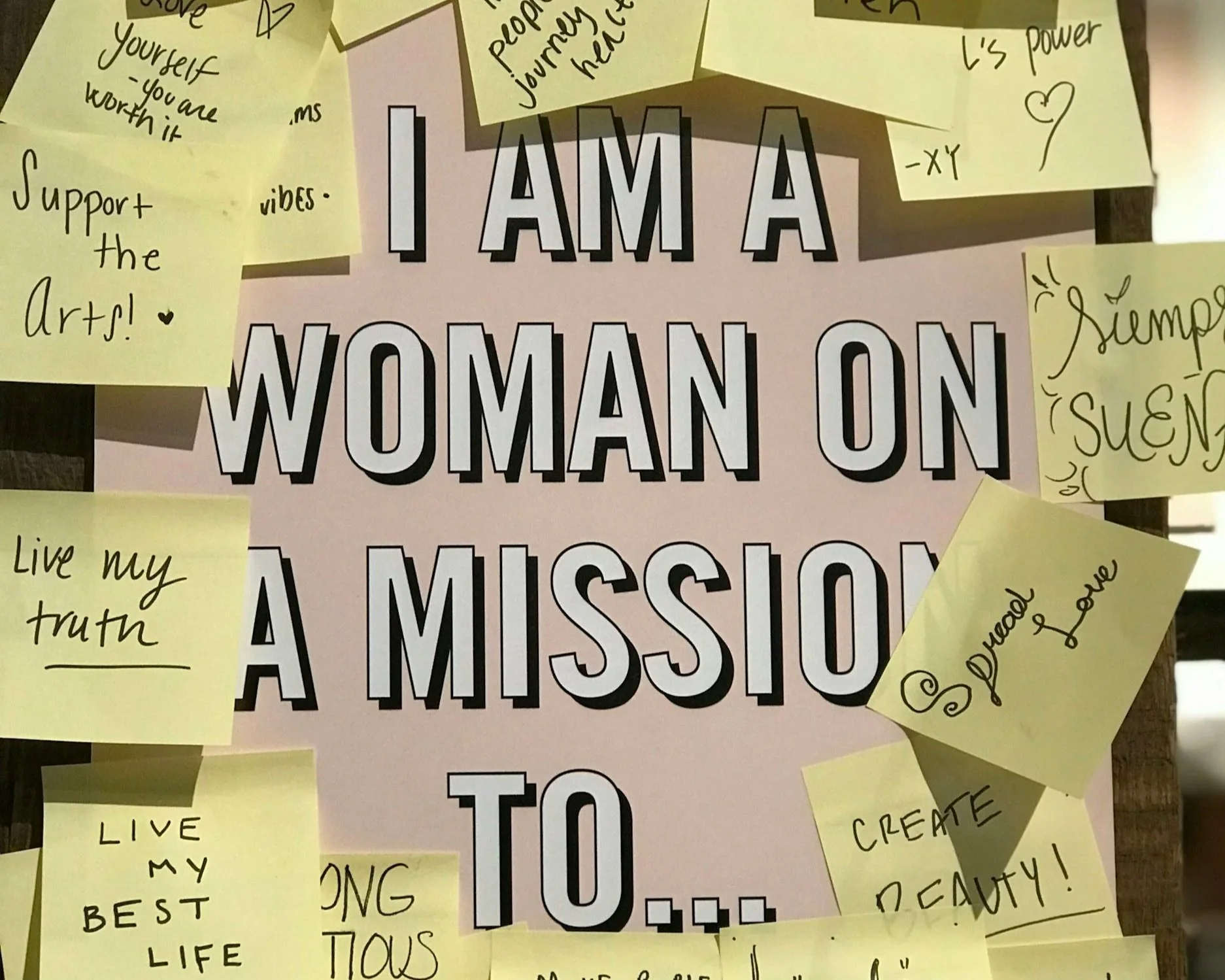 Vision board that says A am a Woman on a Mission with sticky notes with positive affirmations.