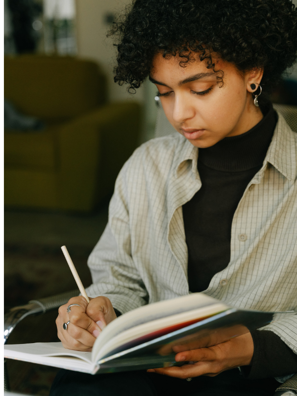 Young woman writing in journal.