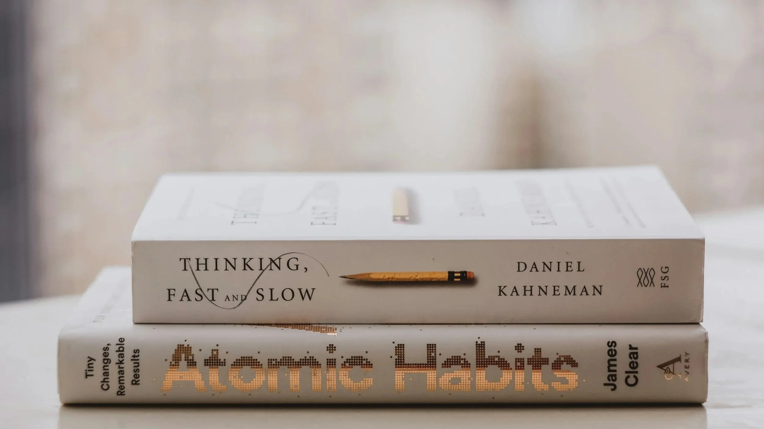A stack of two books, Atomic Habits and Thinking Fast and Slow.