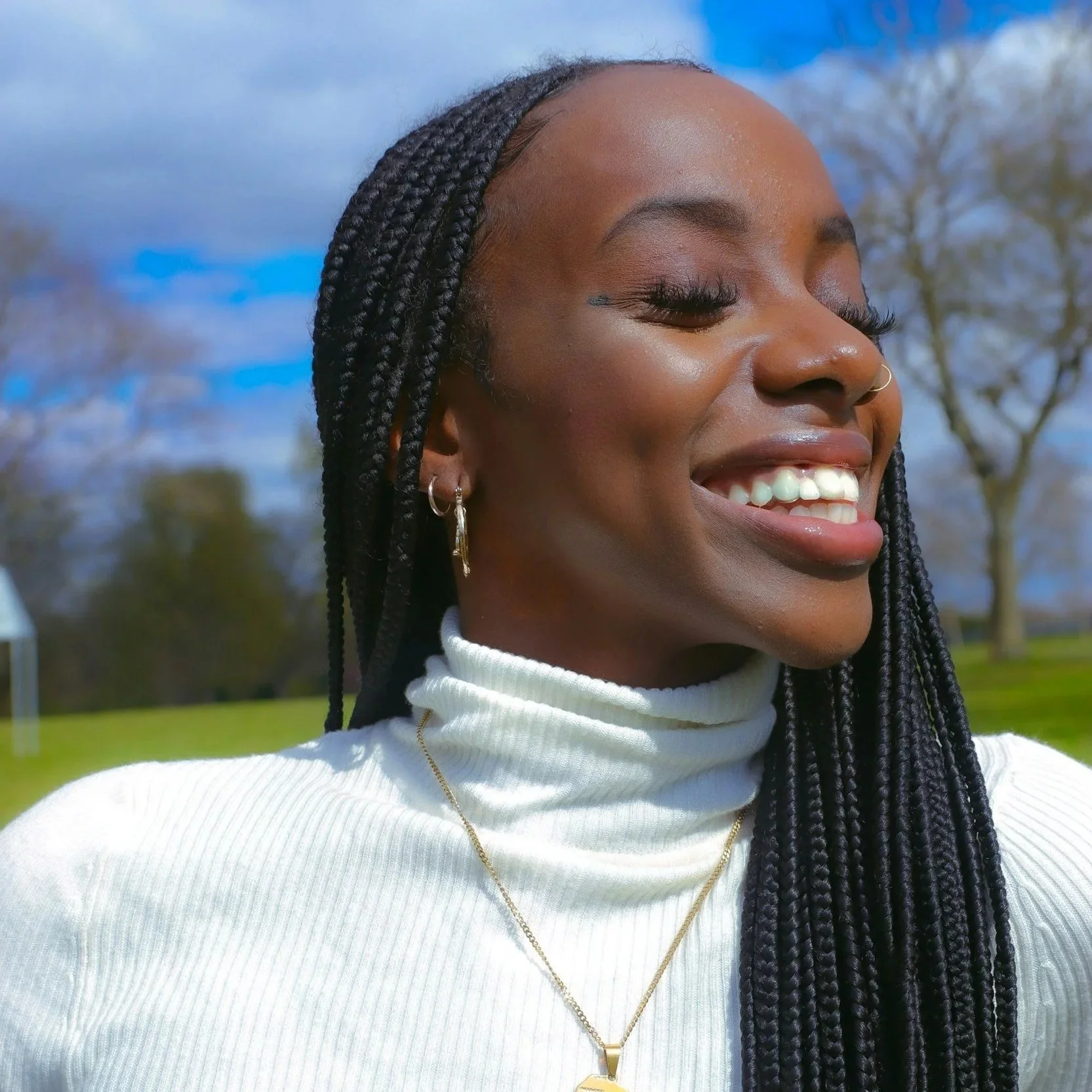 African American woman smiling and standing in the sunshine.