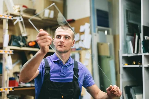 A glass expert cutting custom glass shower pieces.