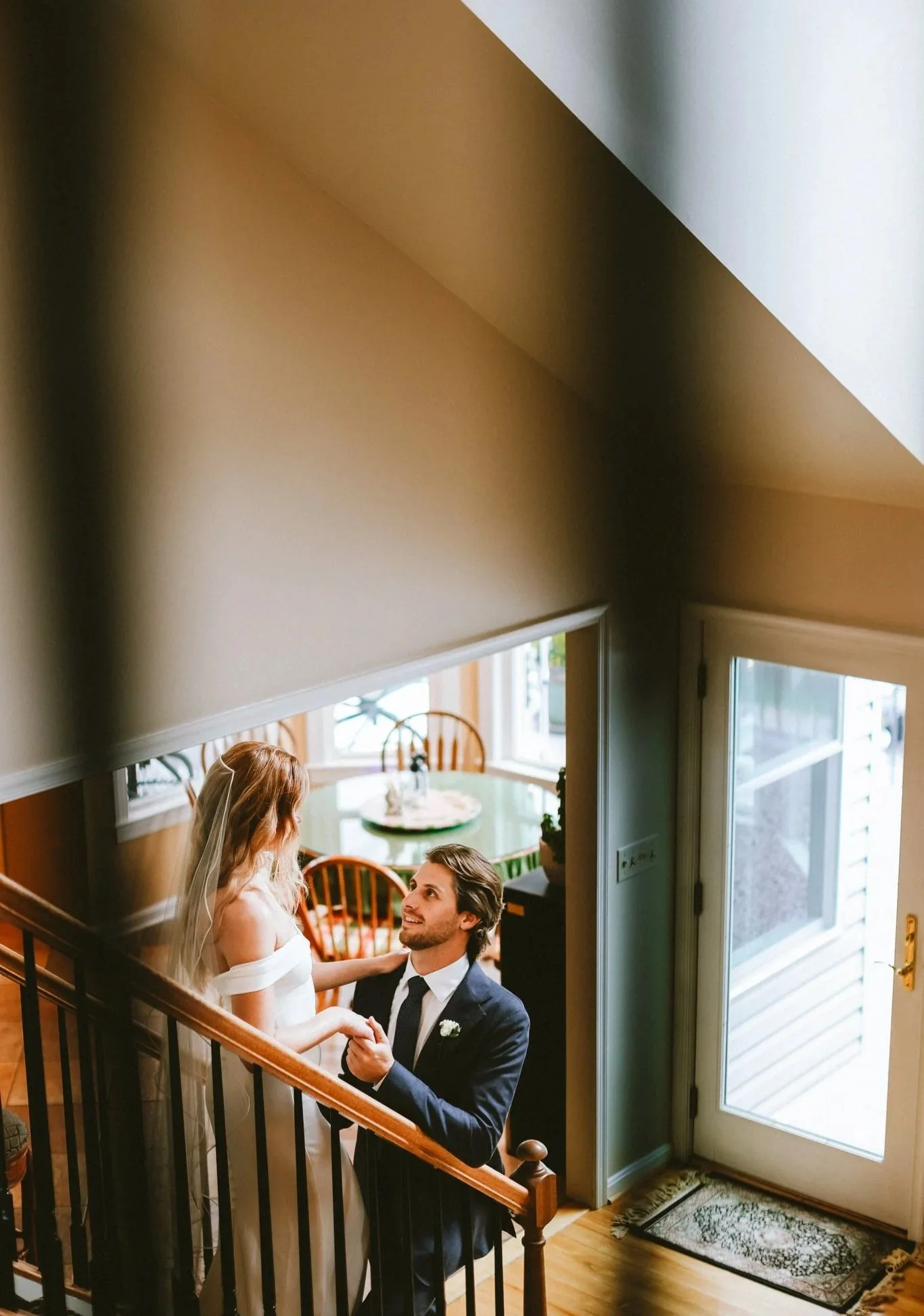 Bride and groom sharing an intimate look moment on a staircase, candid photo