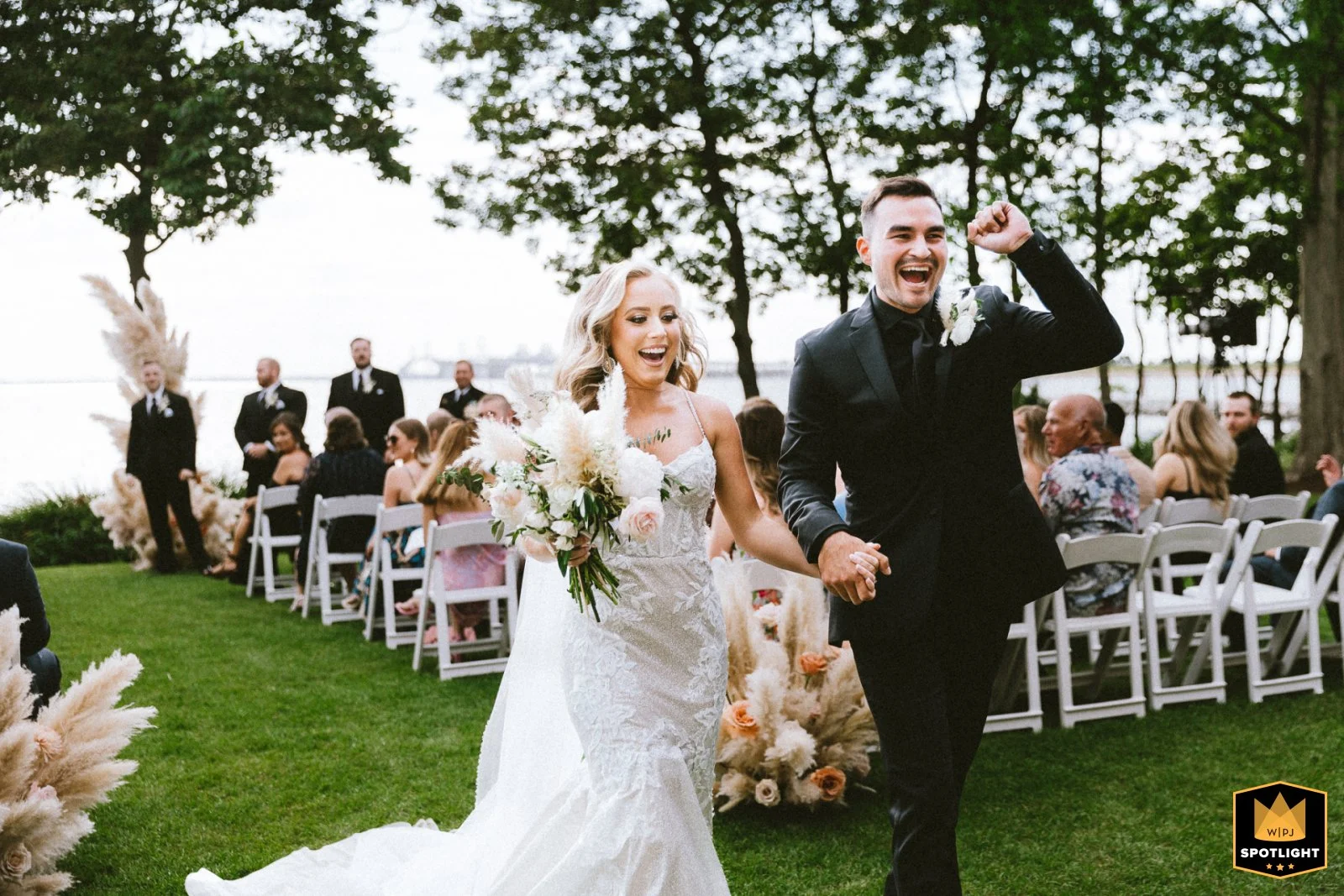 Bride and groom laughing joyfully during outdoor wedding ceremony surrounded by guests, Chesapeake bay beach club Maryland