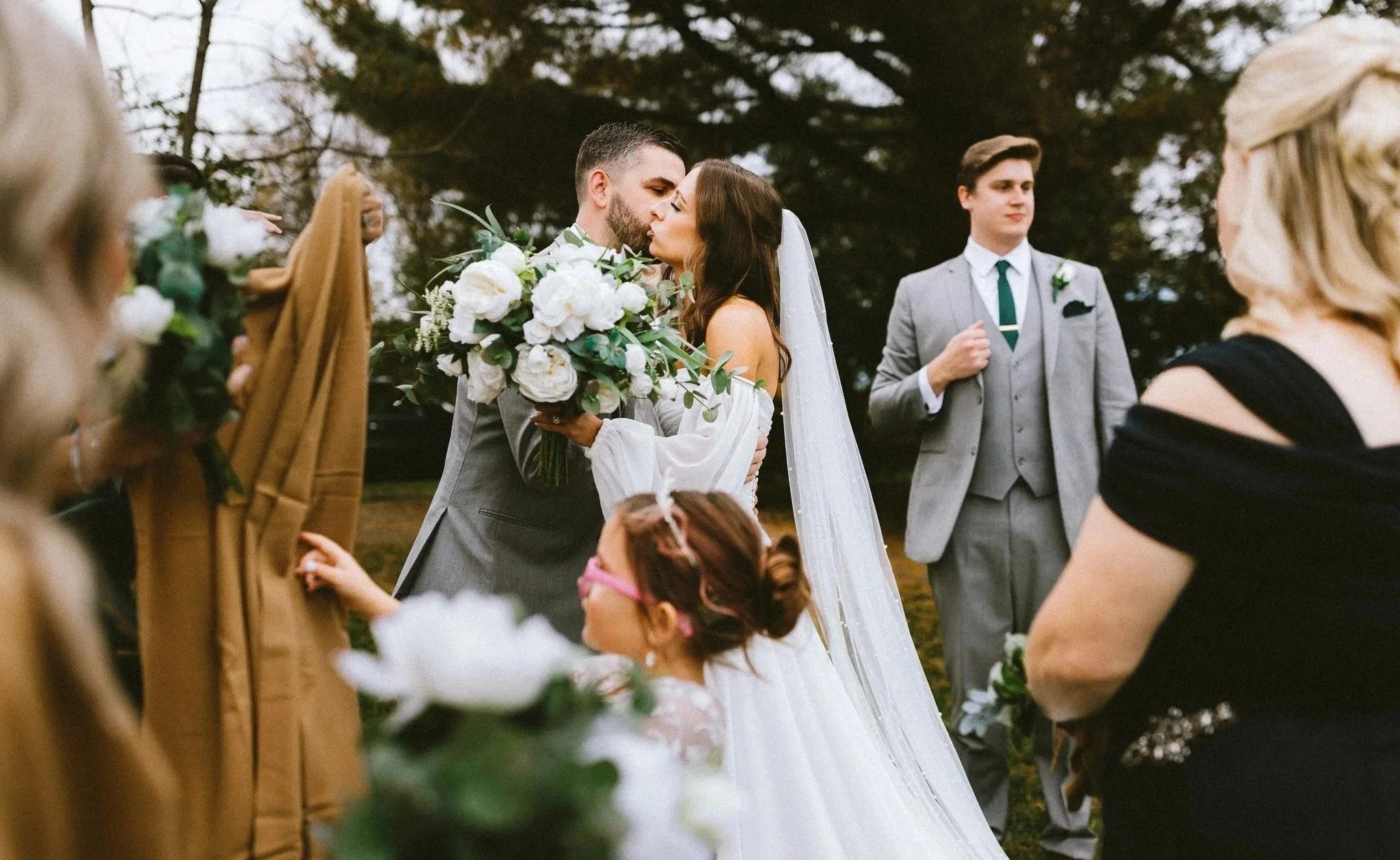 Bride and groom sharing their kiss after outdoor wedding ceremony, documentary wedding photography