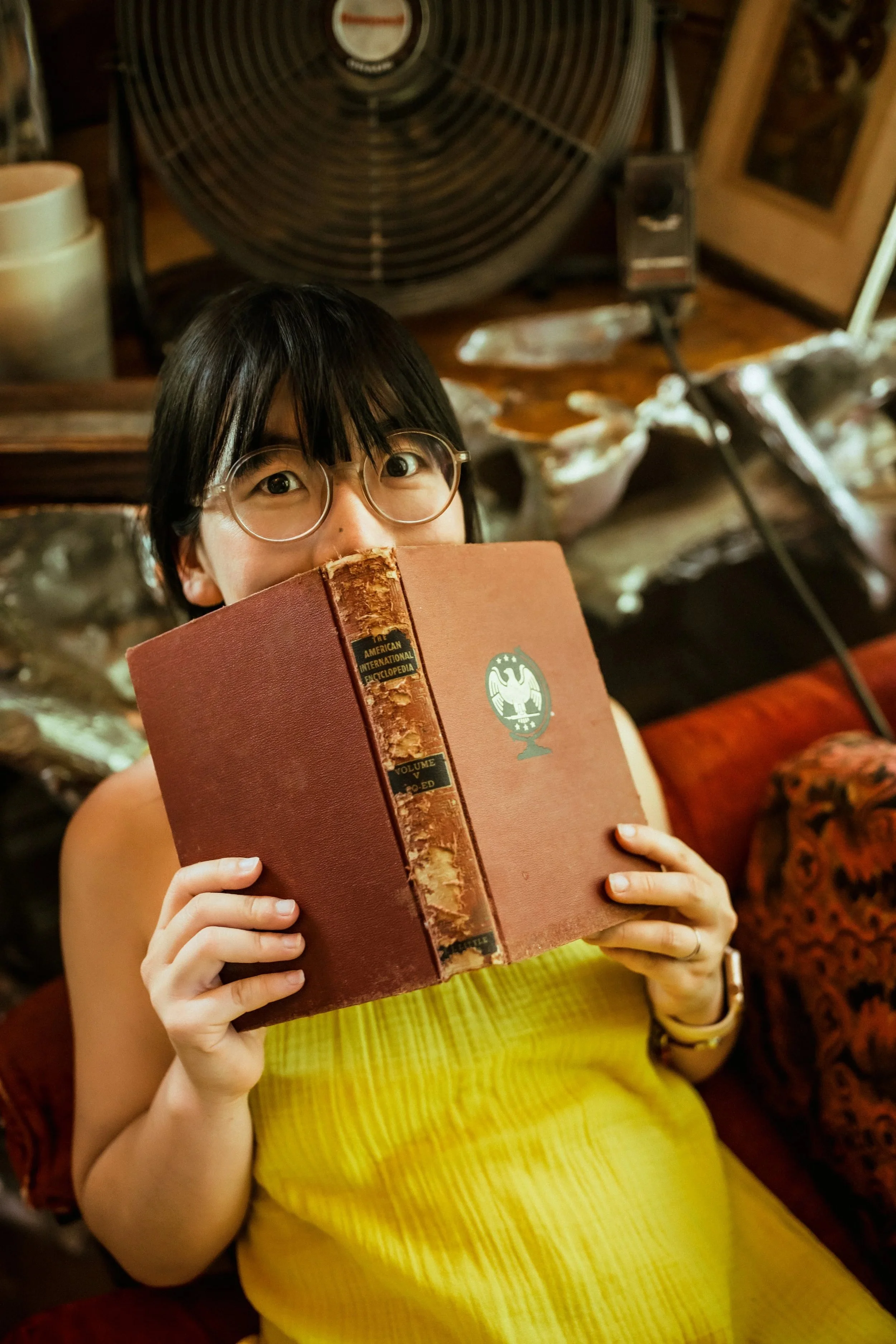 Aira Hickman, Maryland documentary wedding photographer, reading outside with camera
