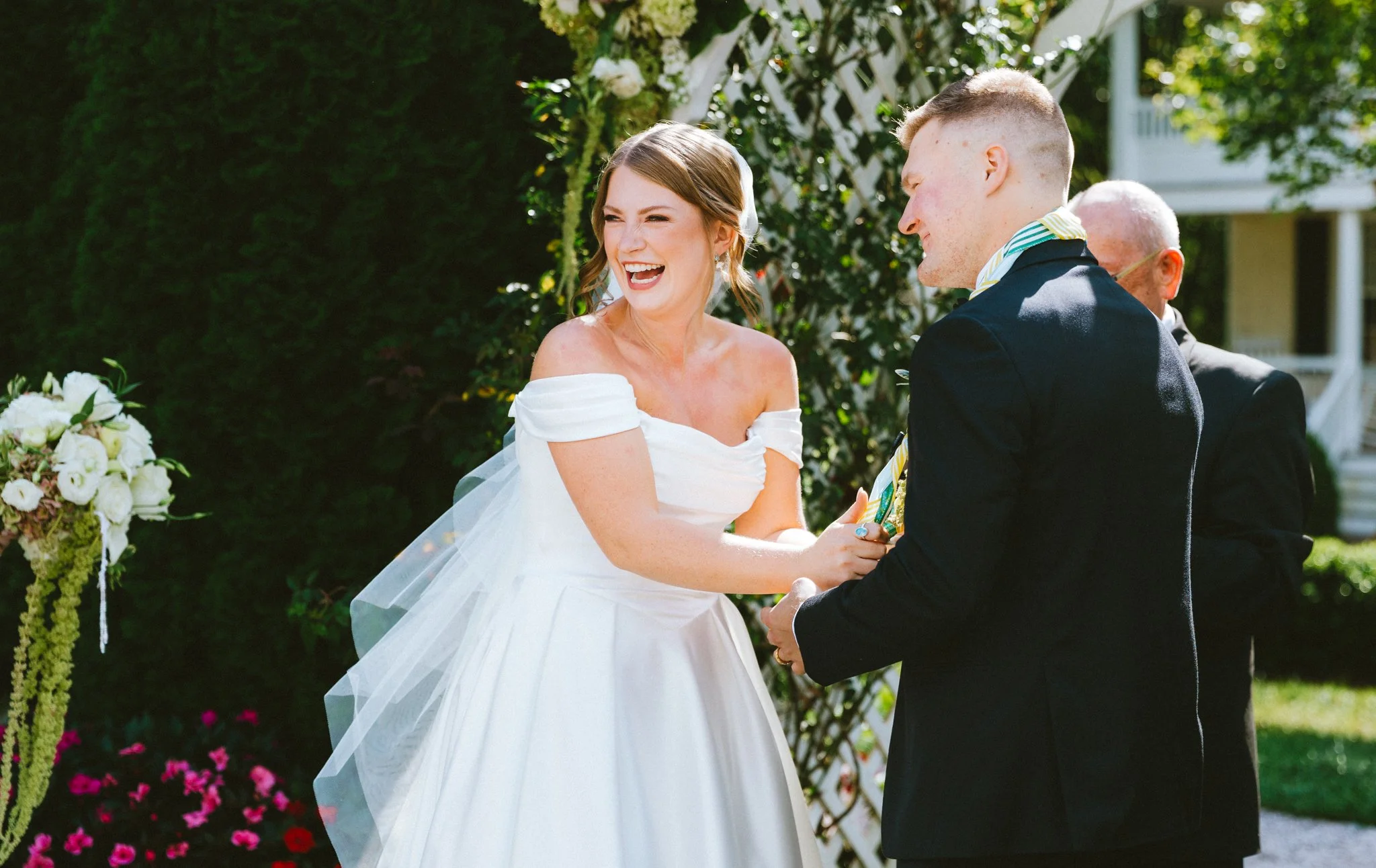 Bride laughing joyfully during outdoor wedding ceremony, by documentary wedding photographer, at Antrim 1844