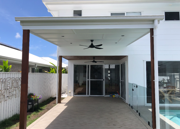 Back patio with wooden floor, two ceiling fans, sliding glass doors, and a glass railing overlooking a swimming pool.