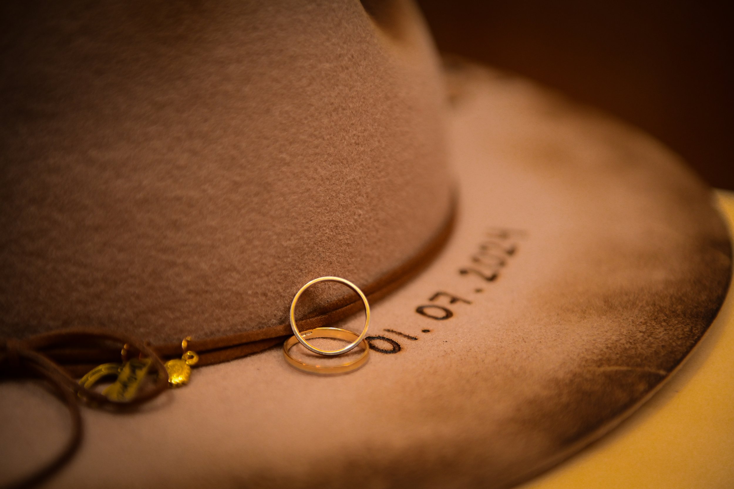 Close-up of gold rings resting on a leather surface with partially visible handwriting.