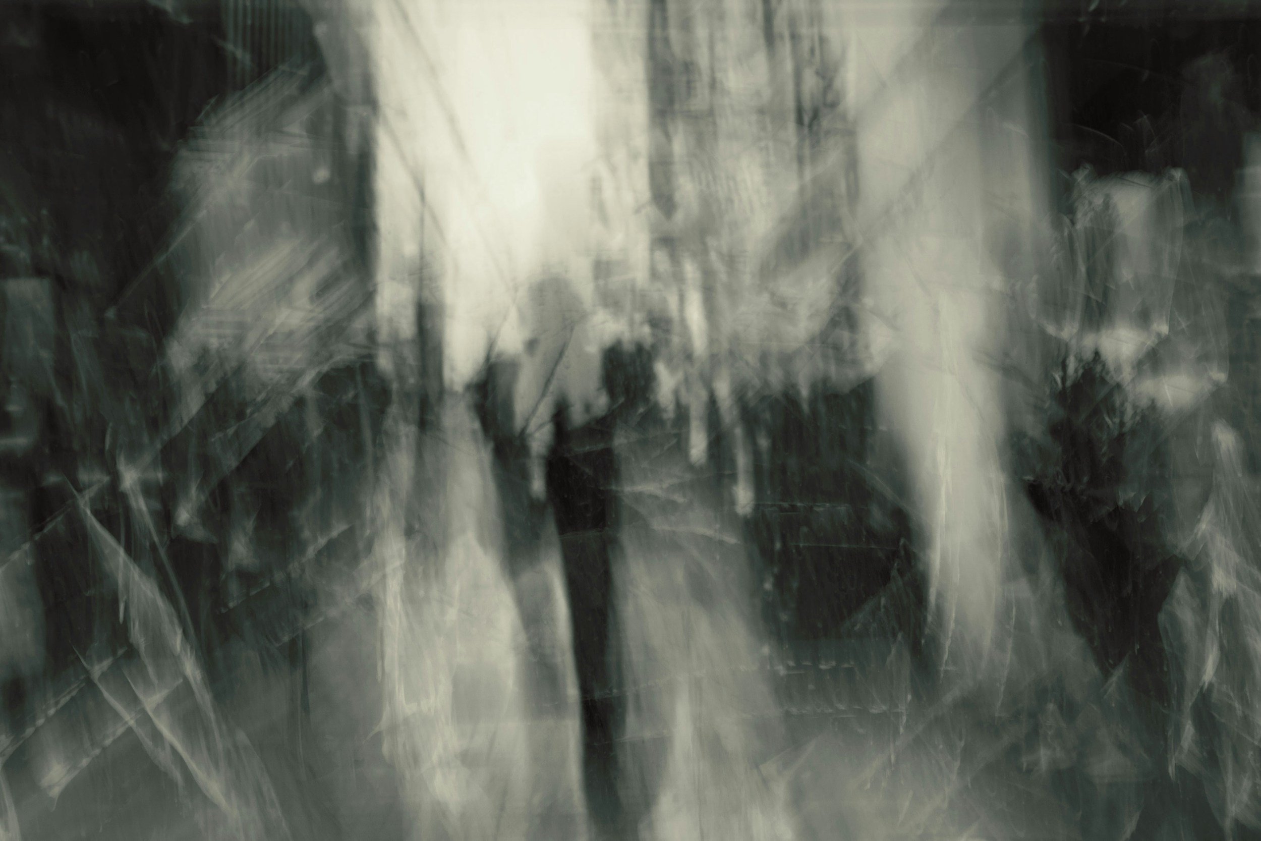 Blurred abstract image with dark and light streaks, possibly of glass or metal surface.