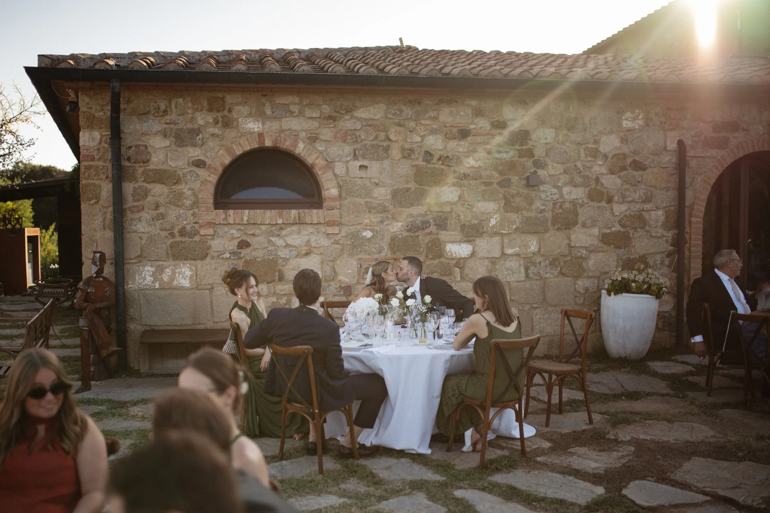 Relaxed and elegant Tuscany wedding dinner under the open sky, with natural white and green wedding styling, long summer evenings and an intimate atmosphere.