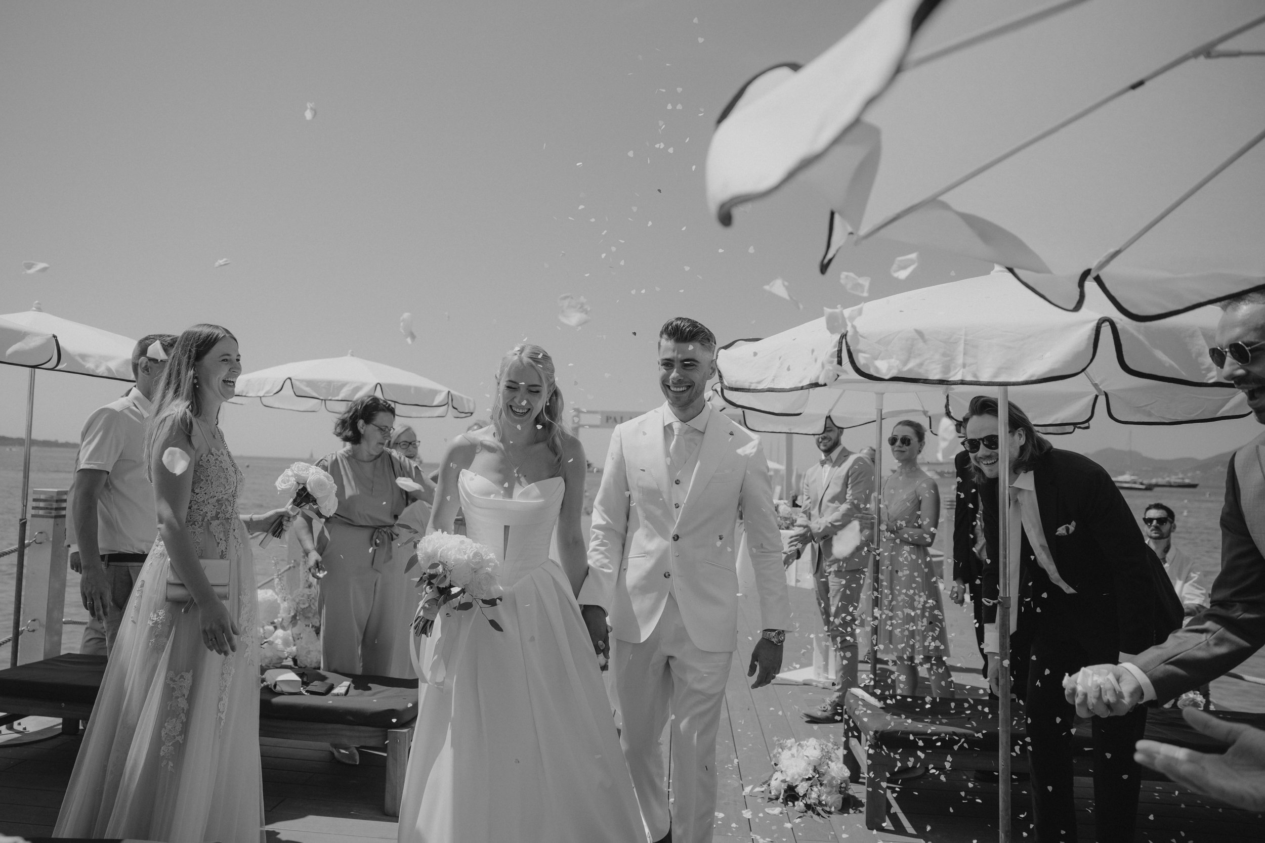 Outdoor wedding ceremony at Stephanie Beach in Cannes overlooking the Mediterranean Sea, surrounded by palm trees and the beautiful coastline of the French Riviera during an intimate luxury wedding.