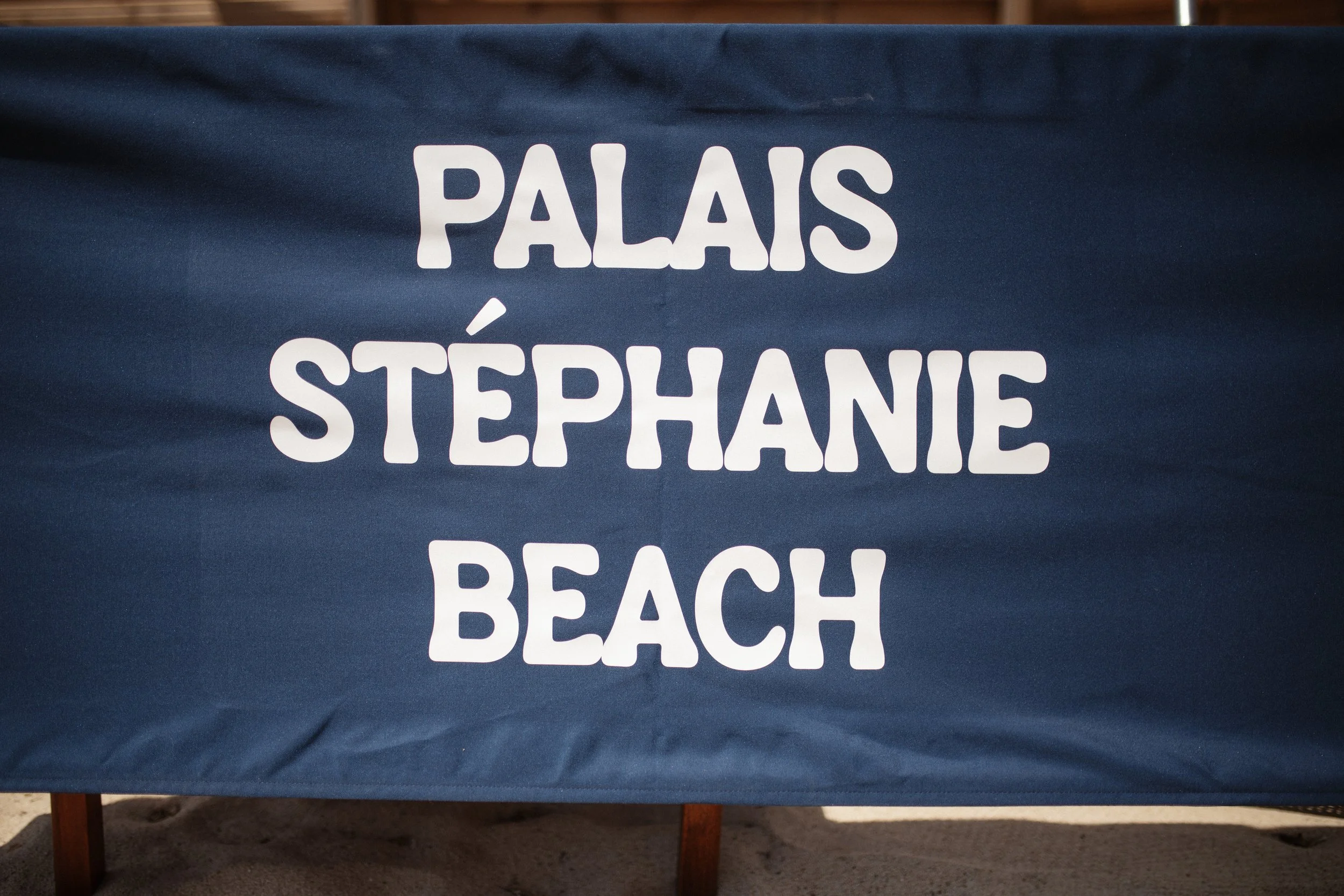 Outdoor wedding ceremony at Stephanie Beach in Cannes overlooking the Mediterranean Sea, surrounded by palm trees and the beautiful coastline of the French Riviera during an intimate luxury wedding.