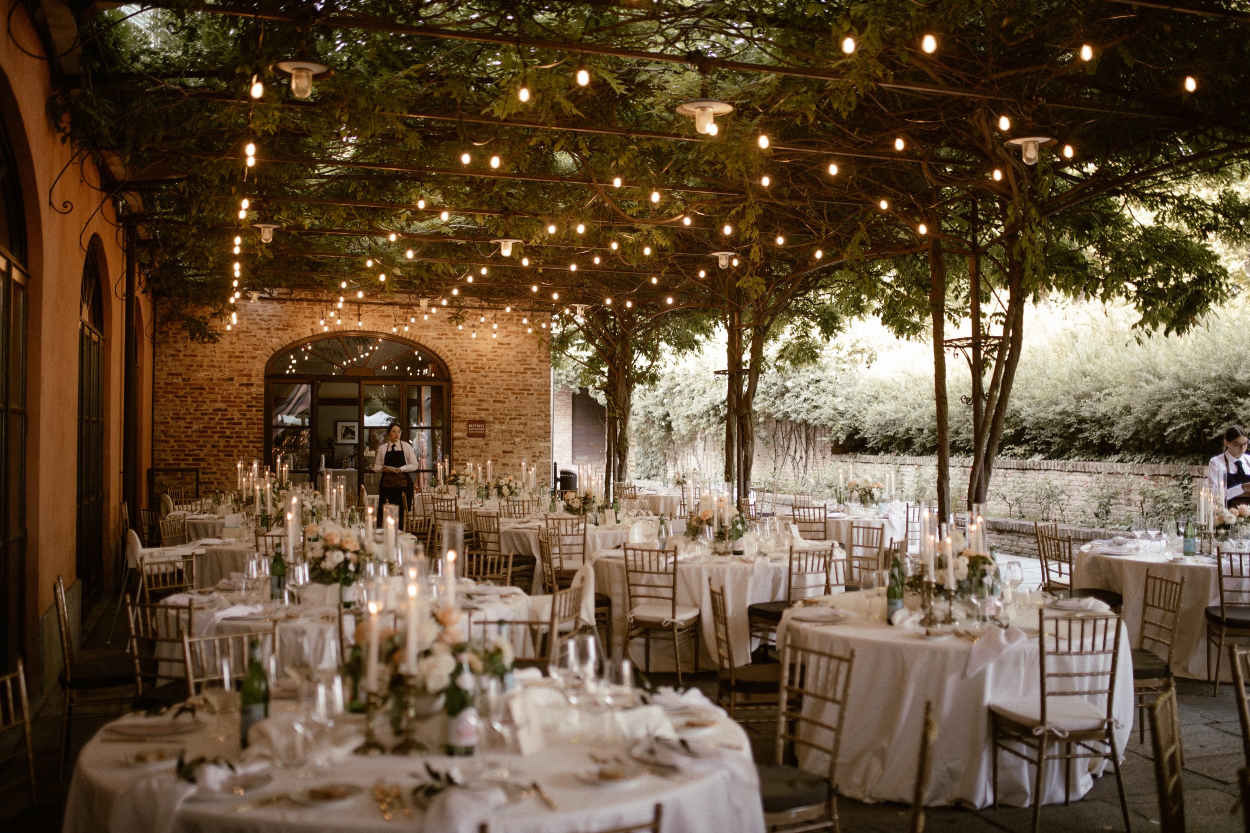 Wedding couple in Italy with fairy lights on pergola overgrown with plants