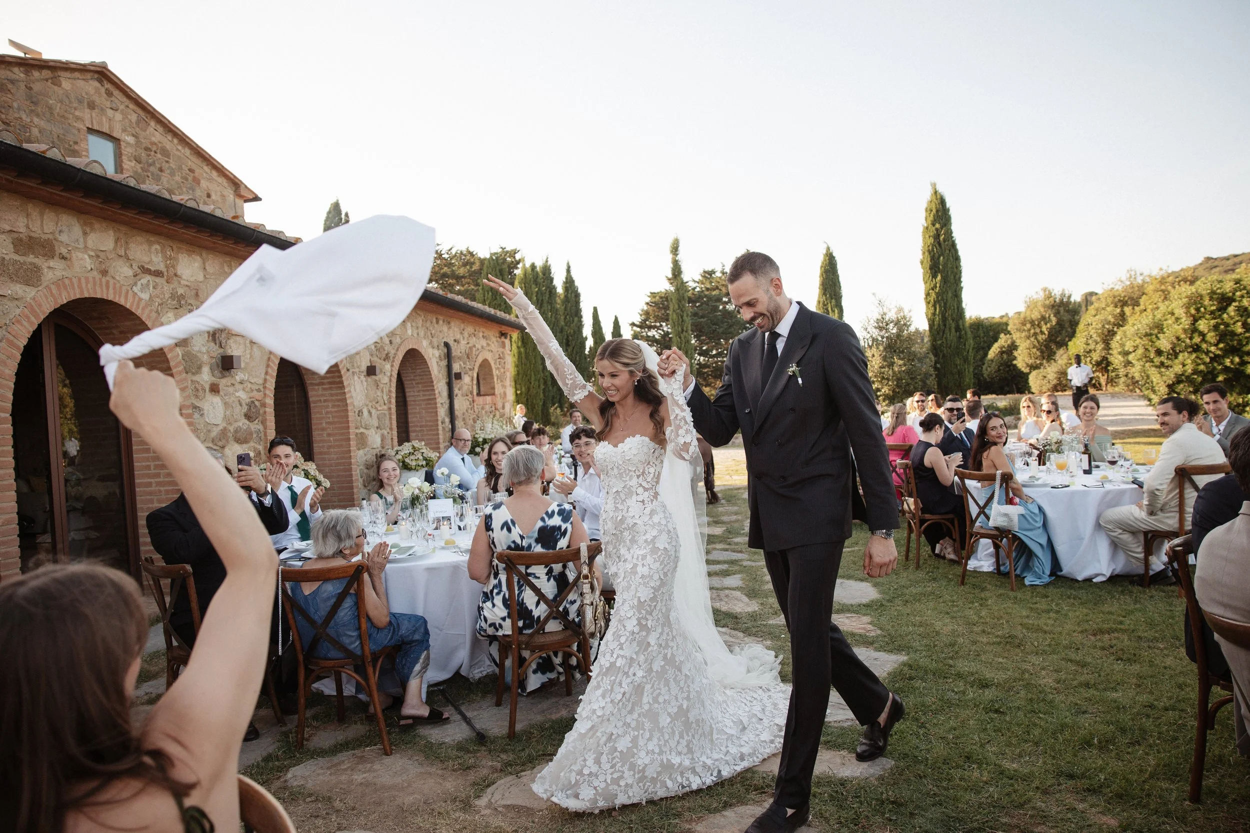 Relaxed and elegant Tuscany wedding dinner under the open sky, with natural white and green wedding styling, long summer evenings and an intimate atmosphere.