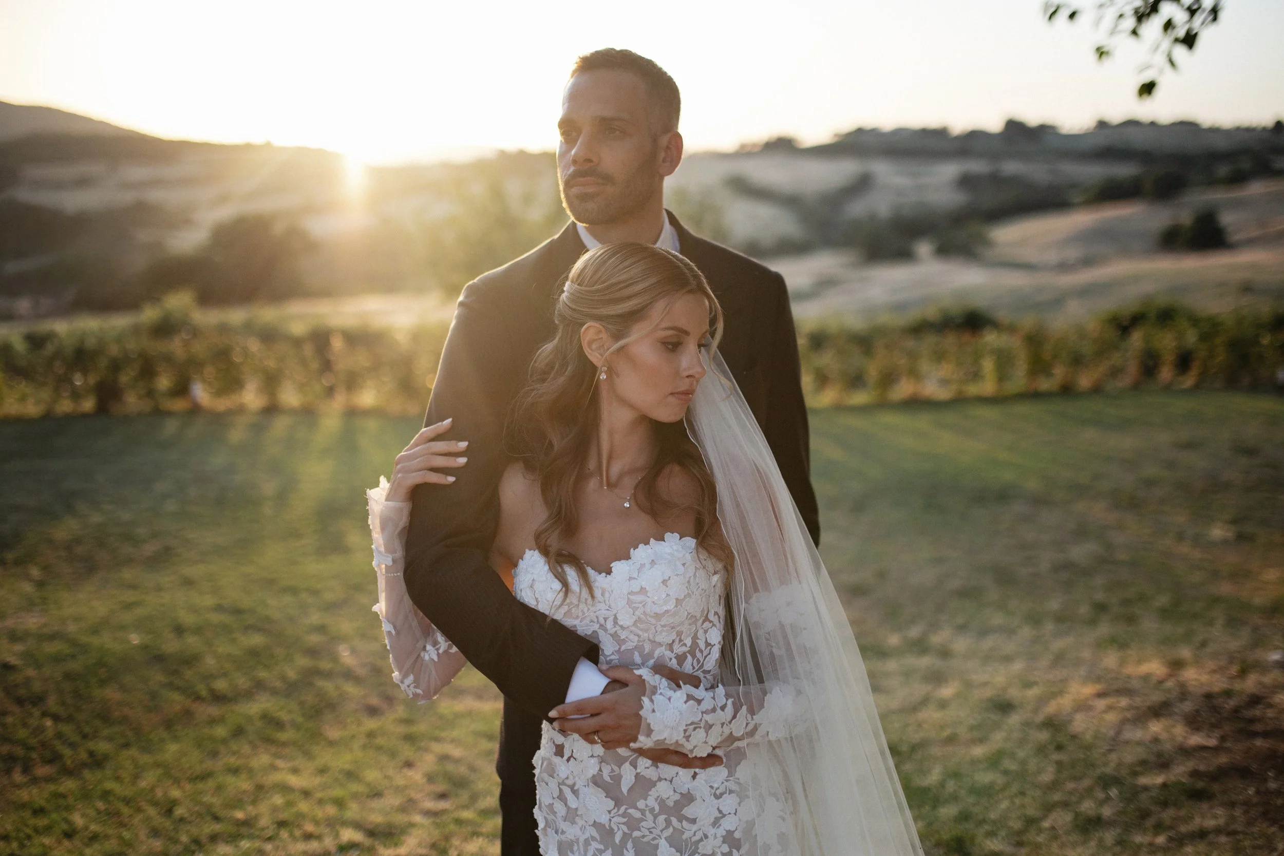 Elegant Tuscany wedding couple portraits in the warm Italian evening light, combining the rustic architecture and natural landscape of Lustignano with a timeless wedding aesthetic.