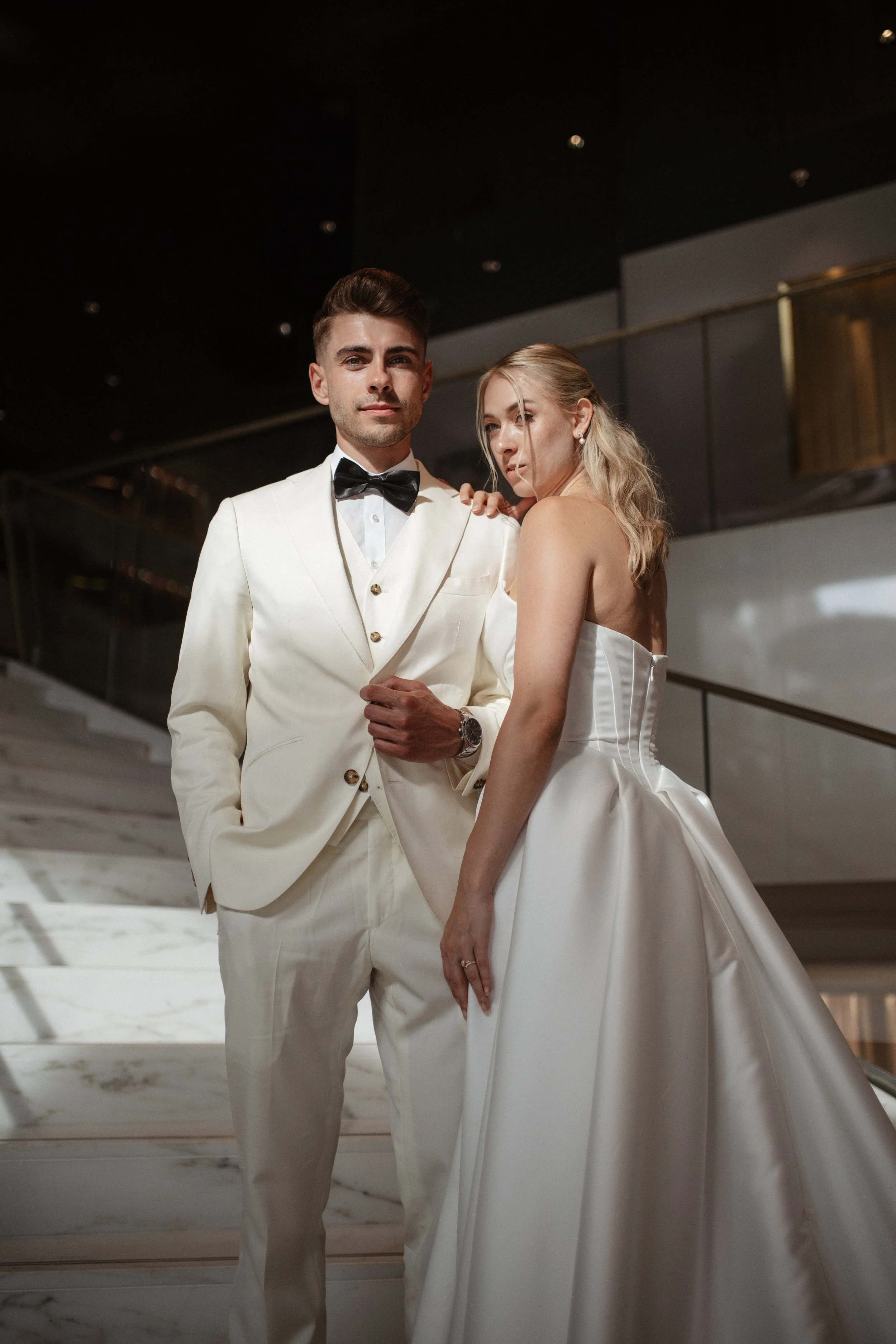 Elegant wedding portraits of the bride and groom along Boulevard de la Croisette in Cannes, featuring a white tuxedo, timeless bridal fashion, Mediterranean architecture, and the iconic French Riviera atmosphere.