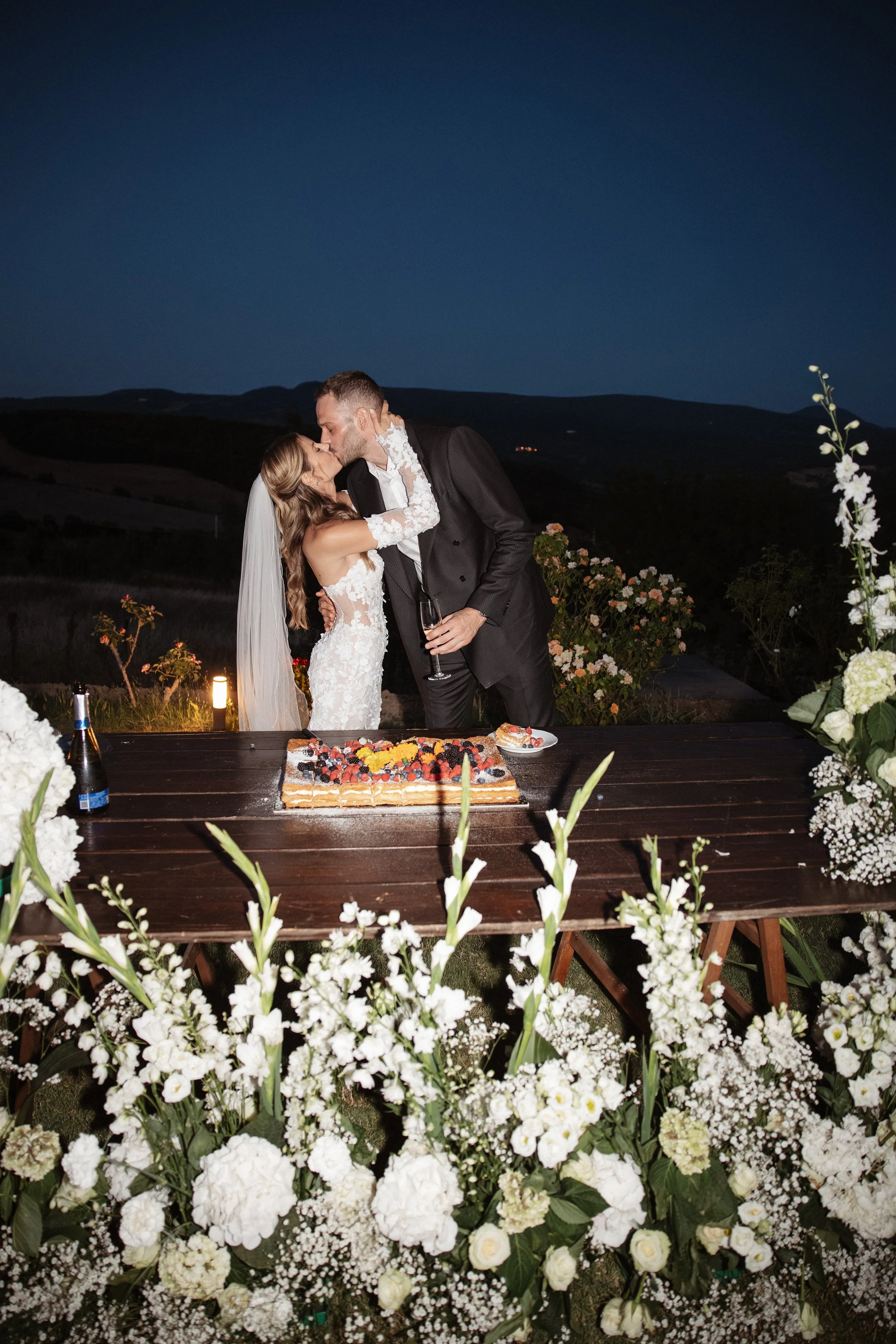 Relaxed and elegant Tuscany wedding dinner under the open sky, with natural white and green wedding styling, long summer evenings and an intimate atmosphere.