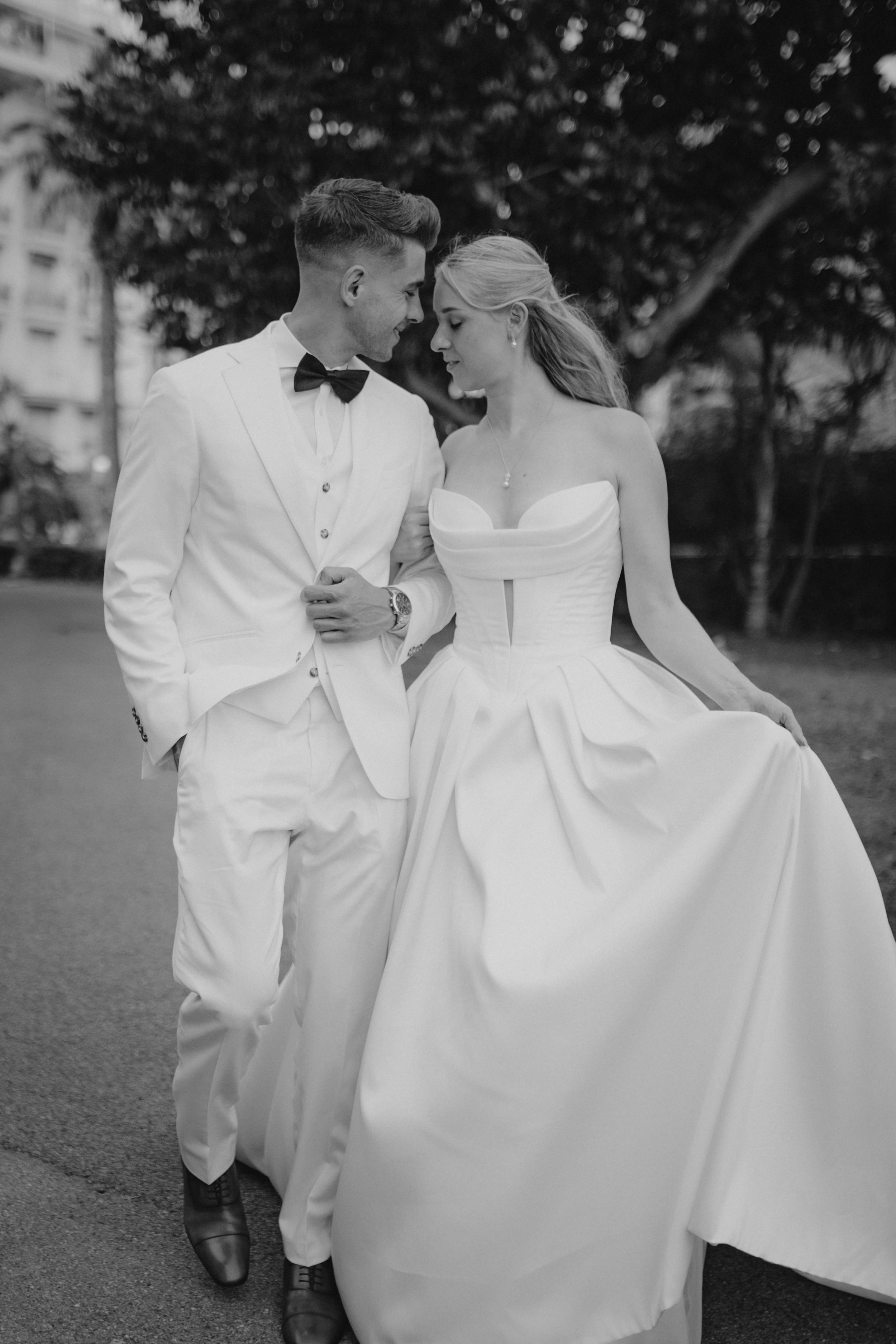 Elegant wedding portraits of the bride and groom along Boulevard de la Croisette in Cannes, featuring a white tuxedo, timeless bridal fashion, Mediterranean architecture, and the iconic French Riviera atmosphere.