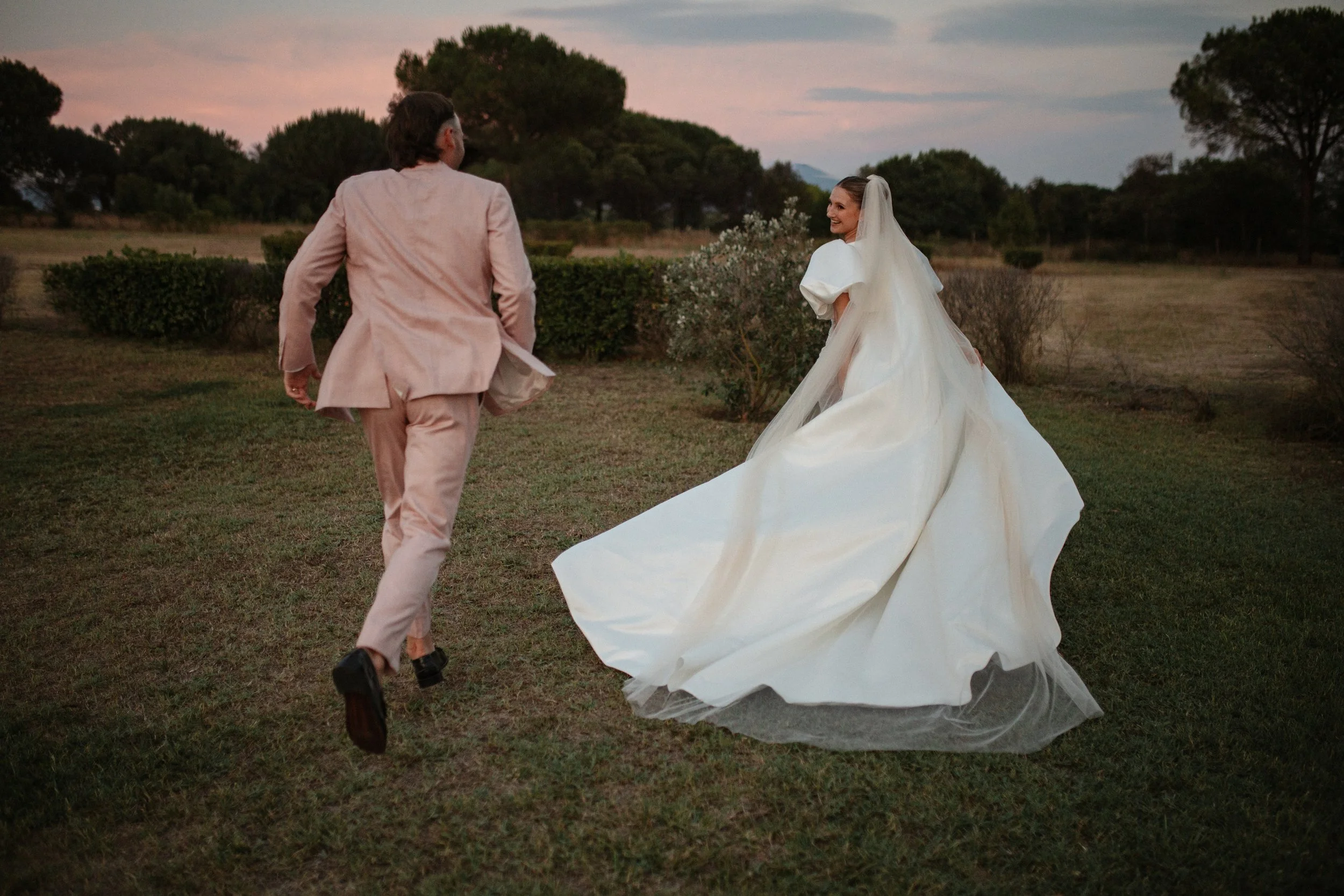 Elegant destination wedding dinner and couple portraits at Casale del Gallo near Rome, with long outdoor tables, natural floral styling and warm Italian evening light.