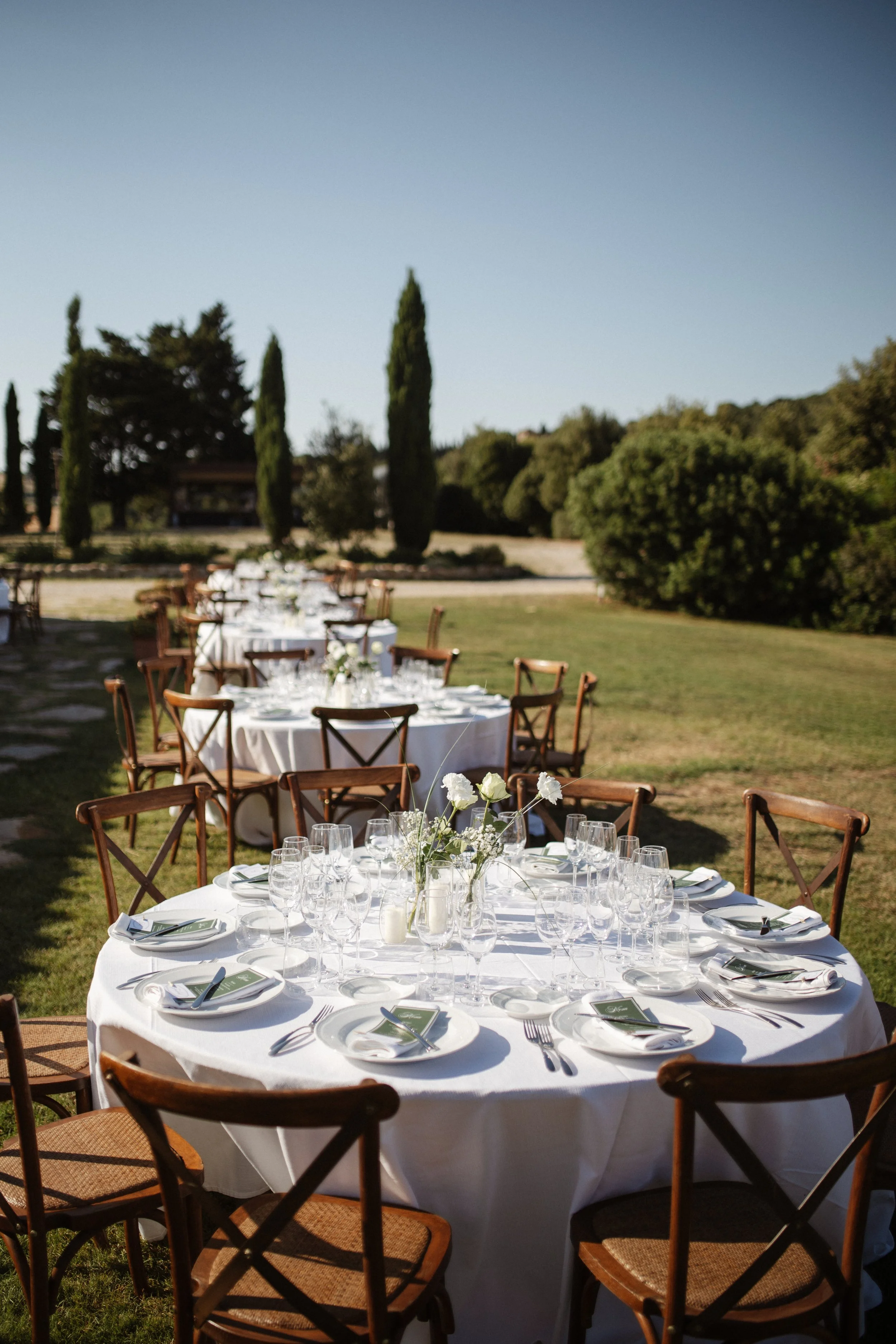 Relaxed and elegant Tuscany wedding dinner under the open sky, with natural white and green wedding styling, long summer evenings and an intimate atmosphere.